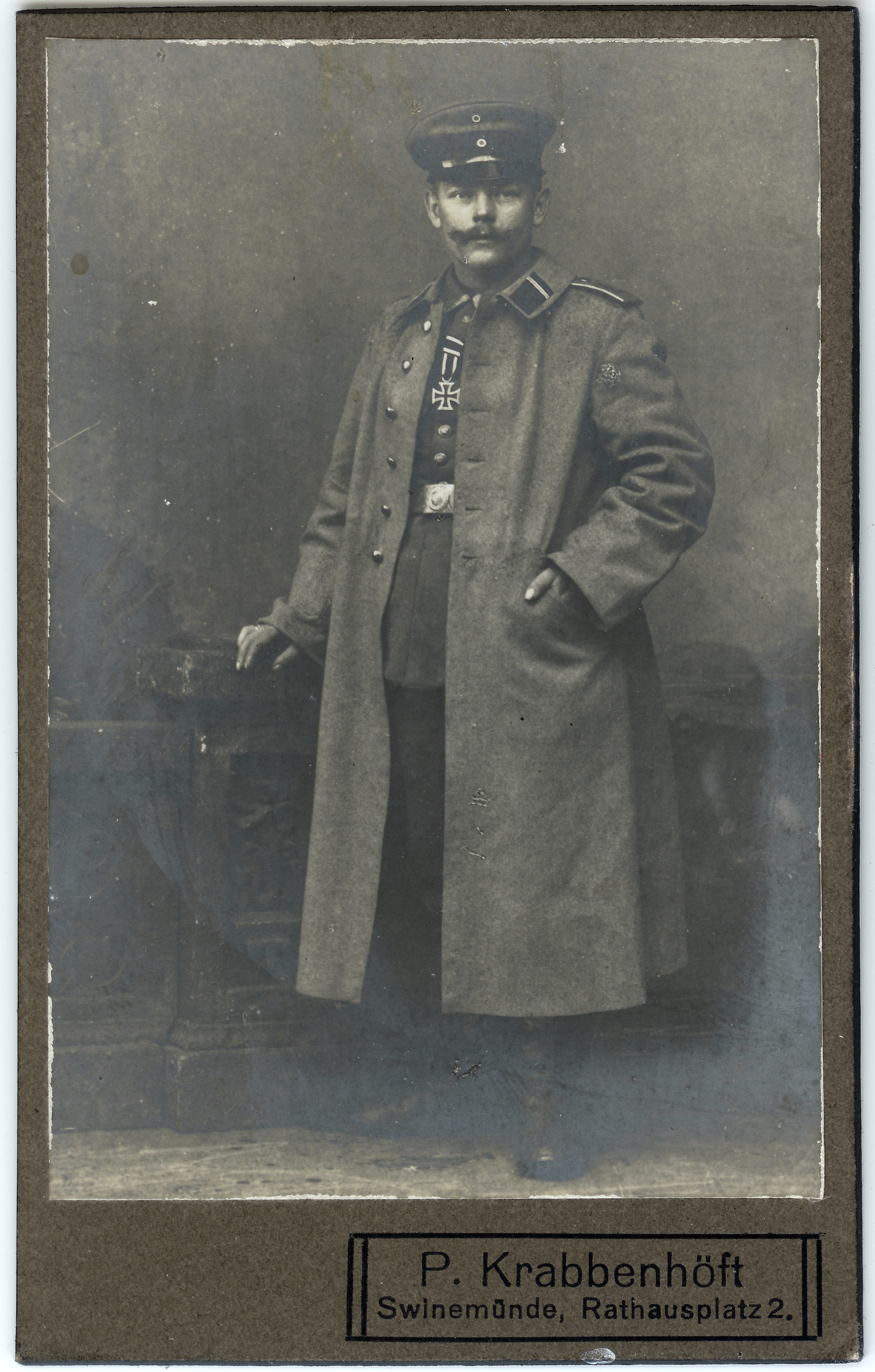 In Uniform und Mantel neben Stuhl (SaHiFo Public Domain Mark)