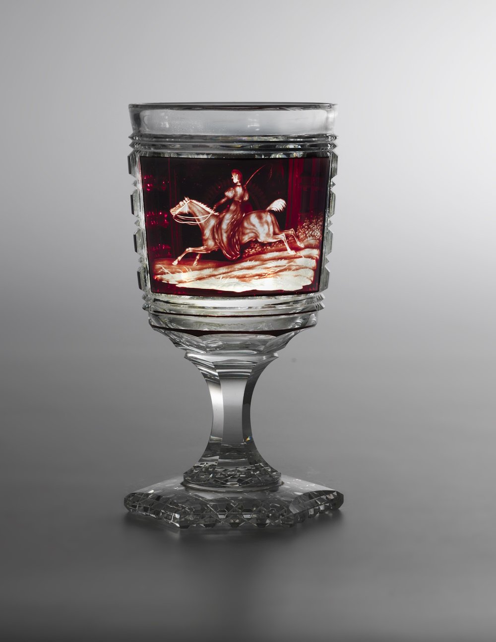 Glaspokal mit Rubinüberfang, im Bildfeld "Peitschenschwingende Reiterin auf gallopierendem Pferd" (Sammlung "S", Wuppertal CC BY-NC-SA)