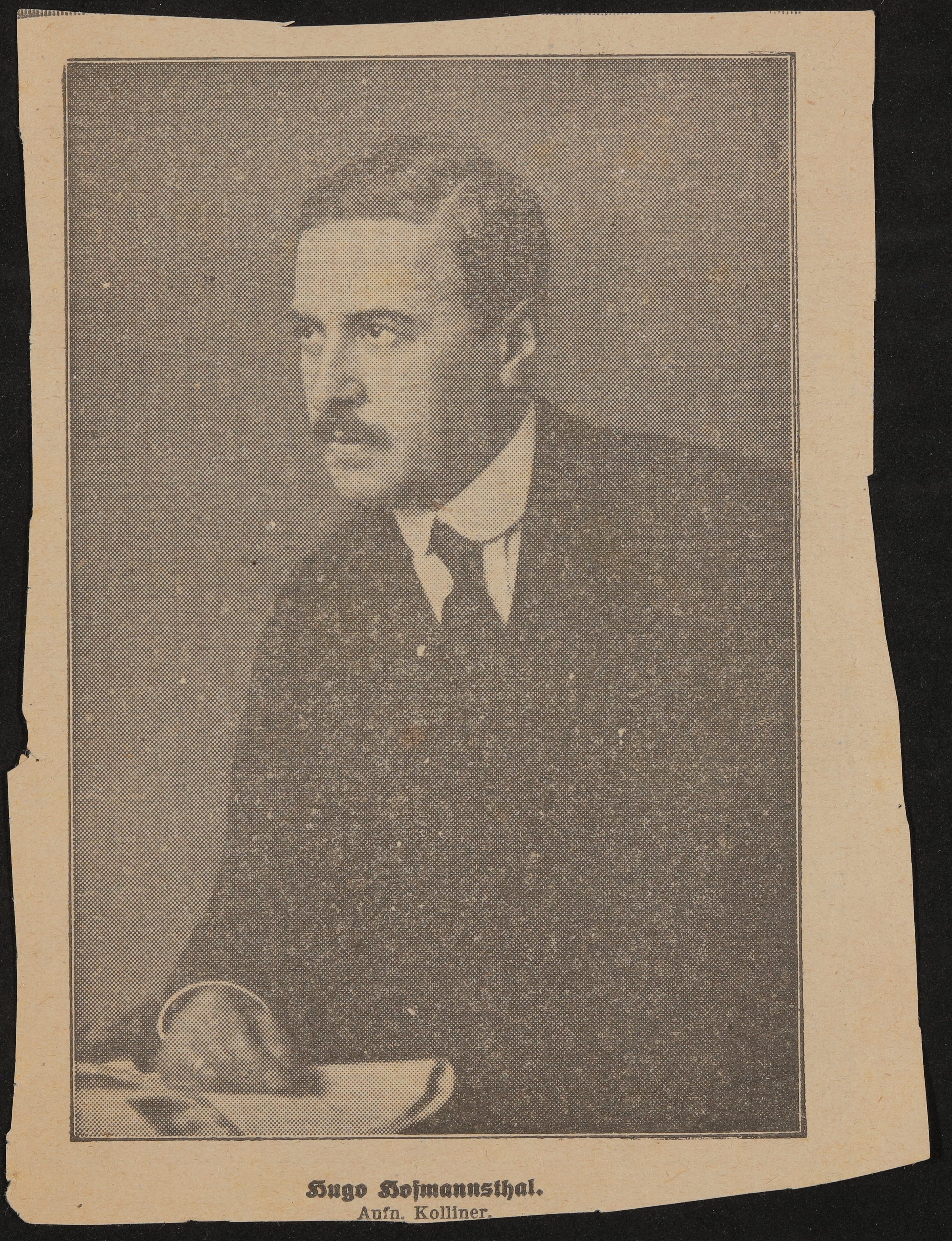 Portrait von Hugo von Hofmannsthal mit der rechten Hand auf einer auf einem Tisch liegenden Zeitung (Freies Deutsches Hochstift / Frankfurter Goethe-Museum CC BY-NC-SA)