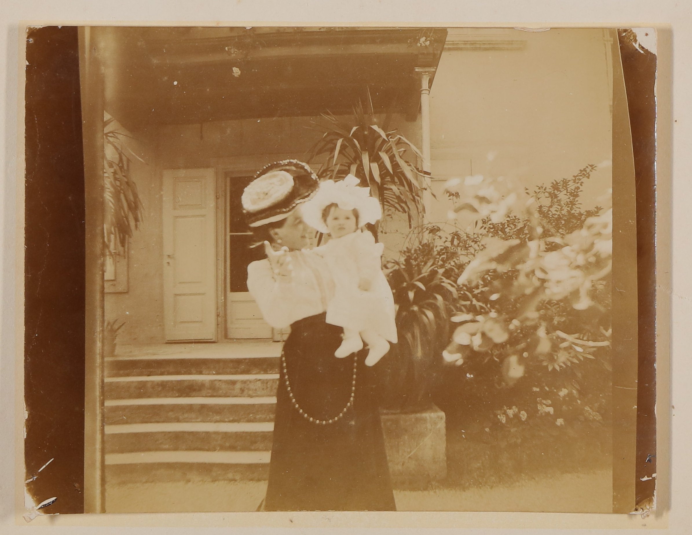 Franziska Schlesinger (?) mit Christiane von Hofmannsthal als Baby auf dem Arm im Garten auf die Kamera zeigend (Freies Deutsches Hochstift / Frankfurter Goethe-Museum CC BY-NC-SA)