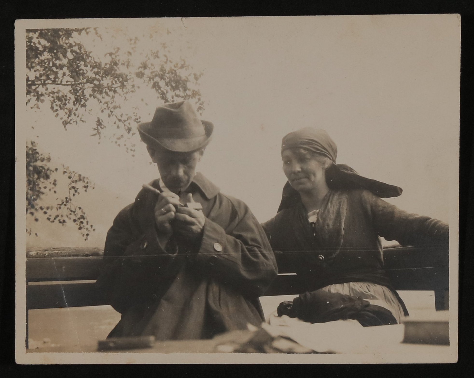 Unbekannter Mann mit Hut und Frau mit Kopftuch sitzen auf einer Holzbank (Vera Graaf CC BY-NC-SA)