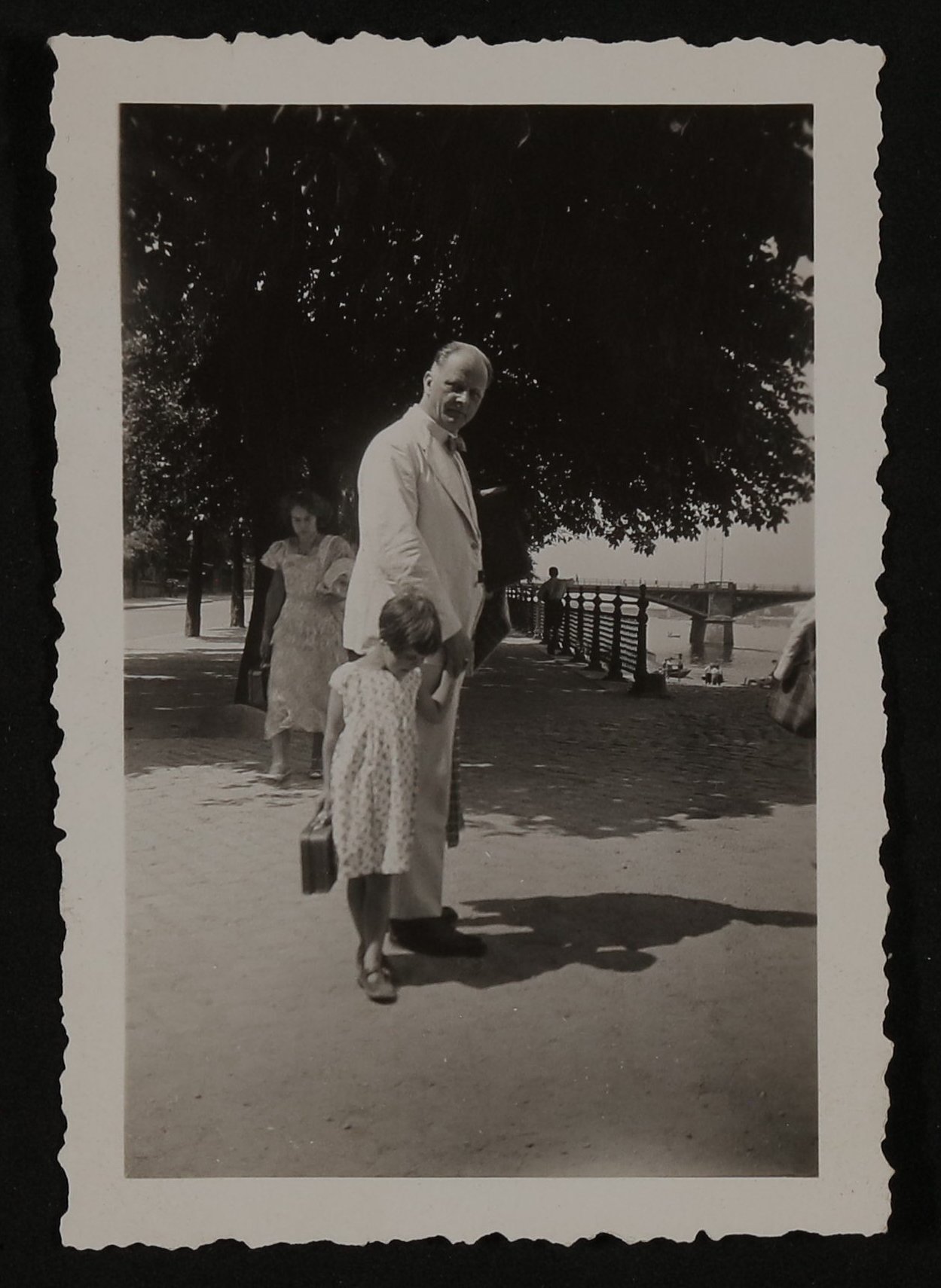 "Vater und Cora August 33" - Ein älterer Herrn in weißem Anzug, an der Hand ein kleines Mädchen mit Koffer (Vera Graaf CC BY-NC-SA)