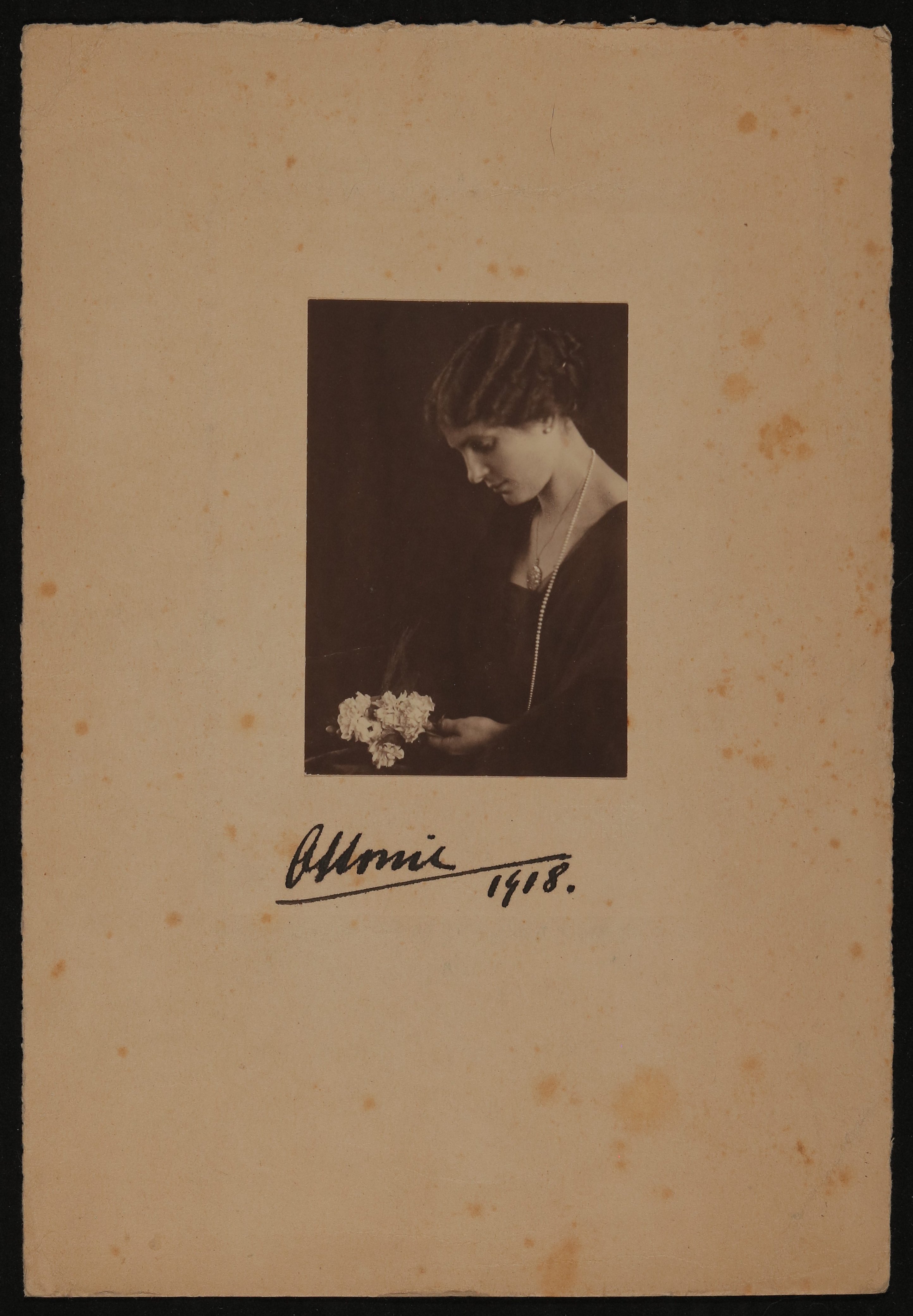 Portrait von Ottonie Degenfeld im schwarzen Kleid mit Perlenkette auf einen Blumenstrauß schauend (Vera Graaf CC BY-NC-SA)