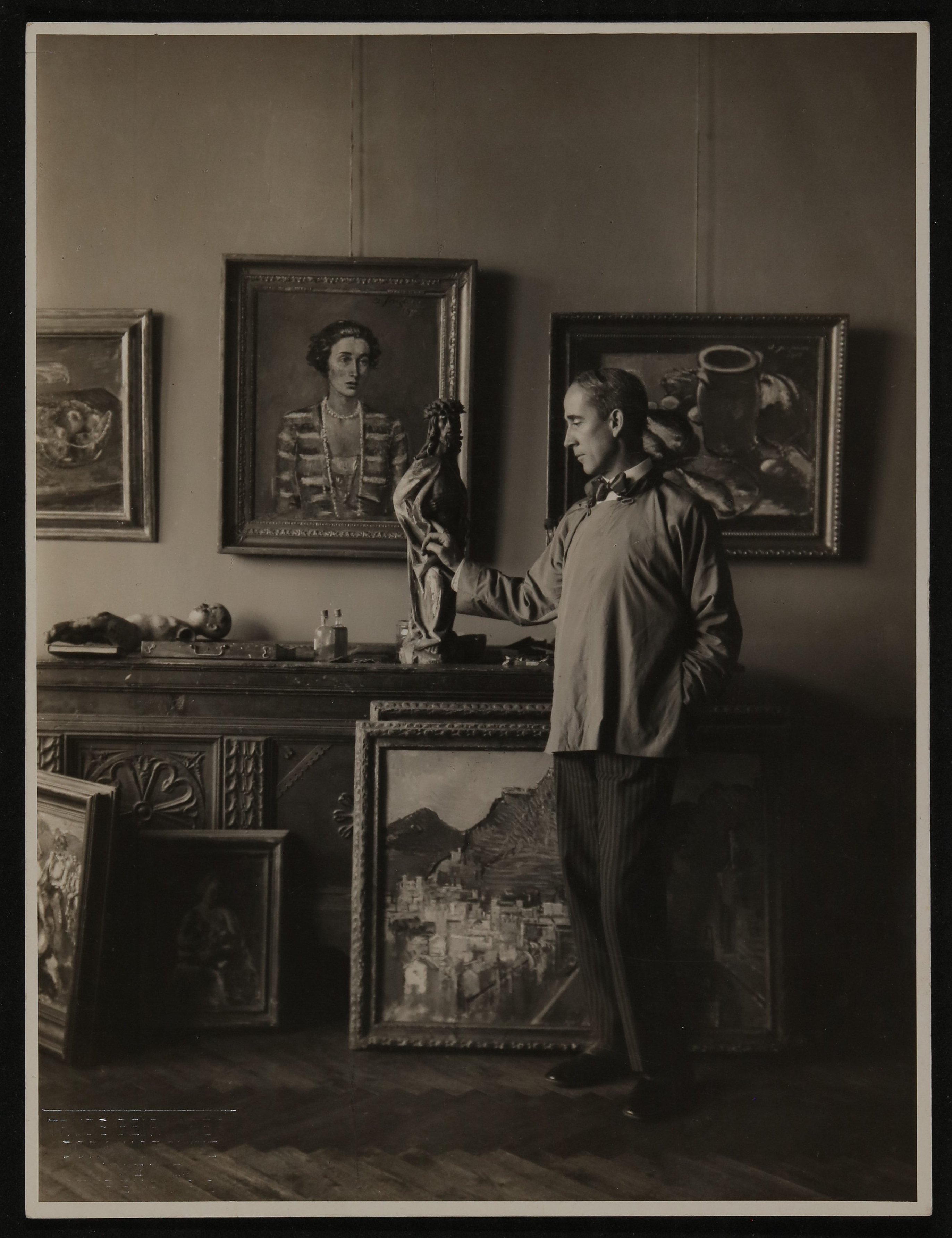 Anton Faistauer in seinem Wohnsimmer stehend, mit Gemälden (Vera Graaf CC BY-NC-SA)