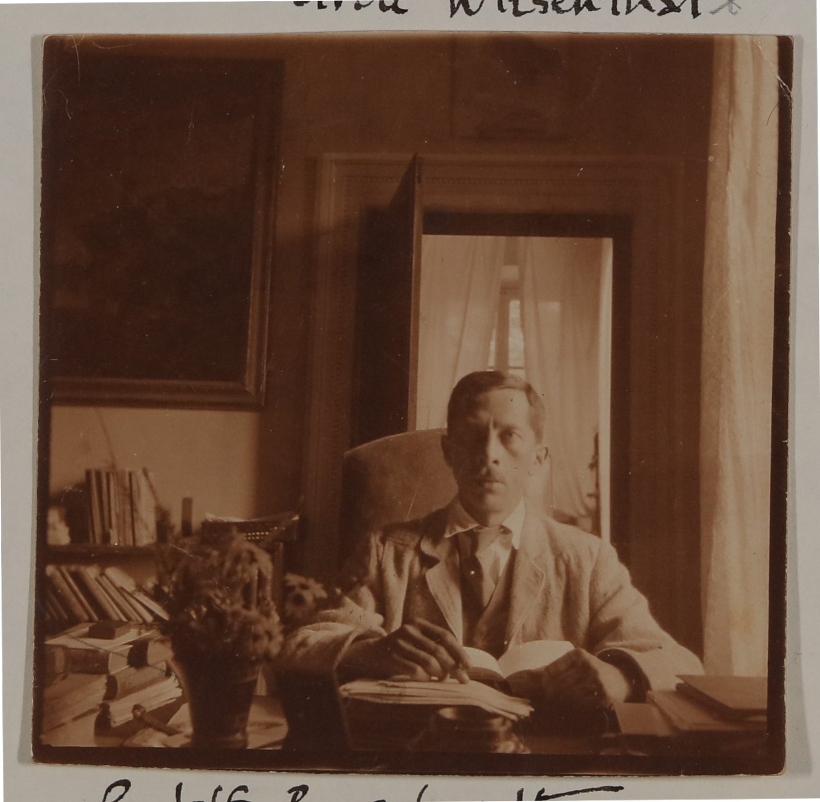 Rudolf Borchardt sitzt mit Buch am Schreibtisch (Vera Graaf CC BY-NC-SA)
