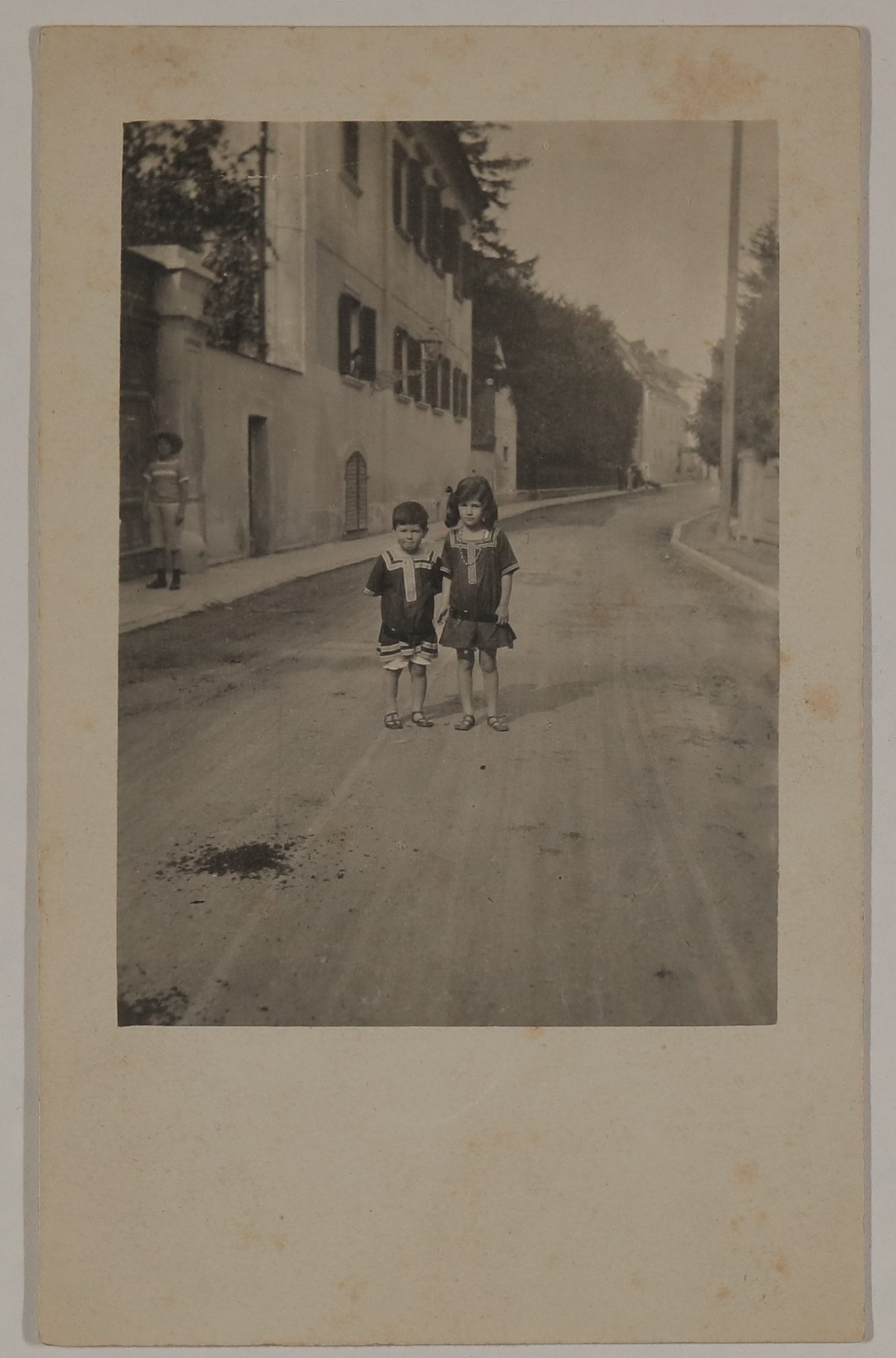 Christiane (rechts) und Franz von Hofmannsthal als Kinder auf der Straße vor dem Rodauner Haus, Passanten im Hintergrund (Vera Graaf Public Domain Mark)