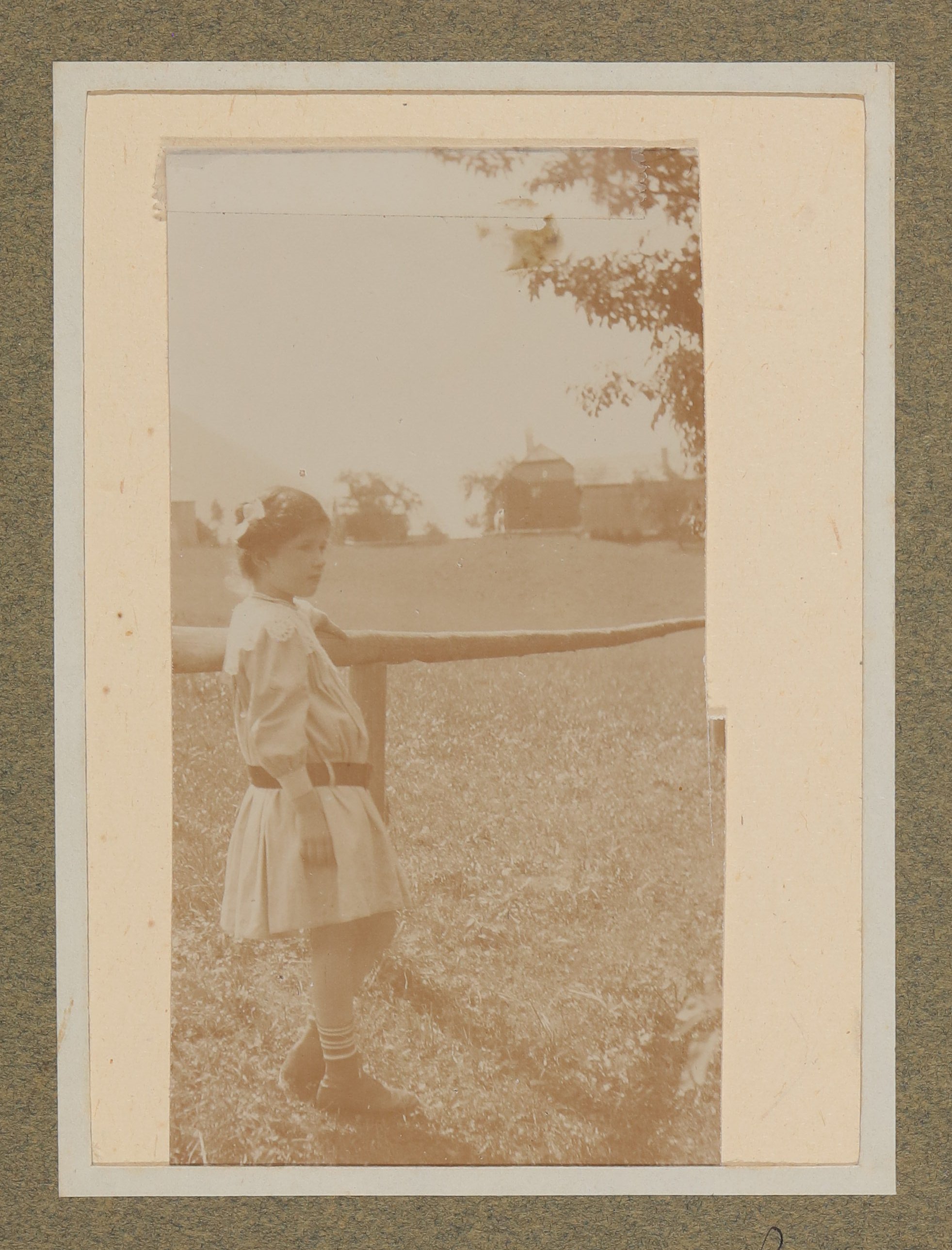 Christiane von Hofmannsthal lehnt als Kind im hellen Sommerkleid mit Gürtel an einem Holzgeländer (Vera Graaf CC BY-NC-SA)