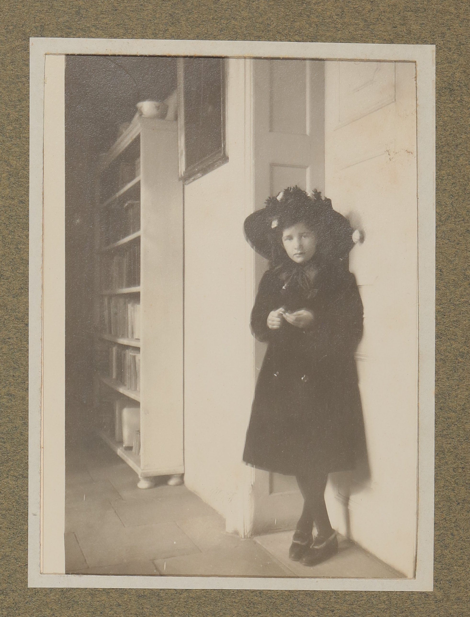 Christiane von Hofmannsthal im dunklen Kleid mit Hut an eine Zimmertür lehnend (Vera Graaf CC BY-NC-SA)