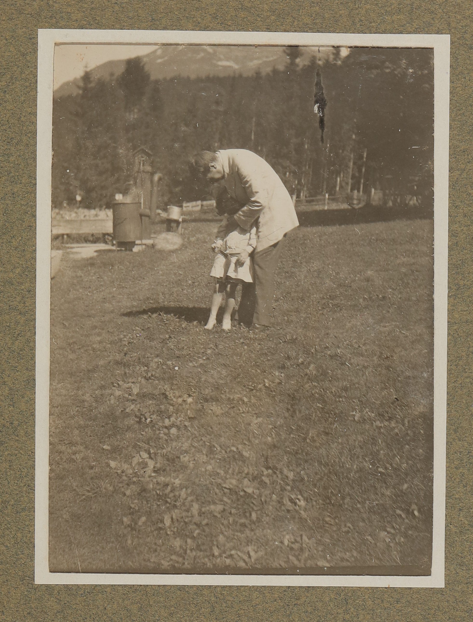 Hugo von Hofmannsthal mit einem Kind (Raimund oder Christiane?) im Garten stehend, sich zum Kind hinunterbeugend (Vera Graaf CC BY-NC-SA)