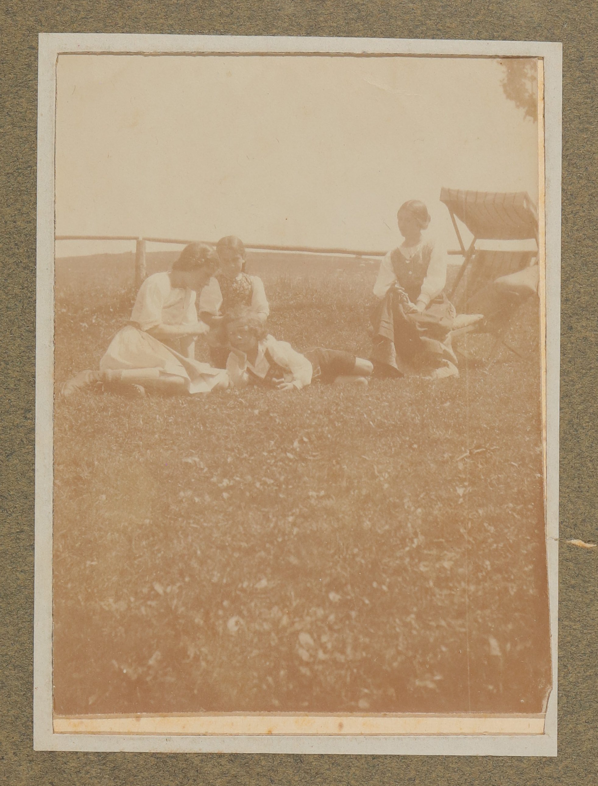 Raimund von Hofmannsthal liegt mit zwei Frauen und einem Mädchen an einem Holzgeländer in Aussee, mit Liegestuhl (Vera Graaf CC BY-NC-SA)