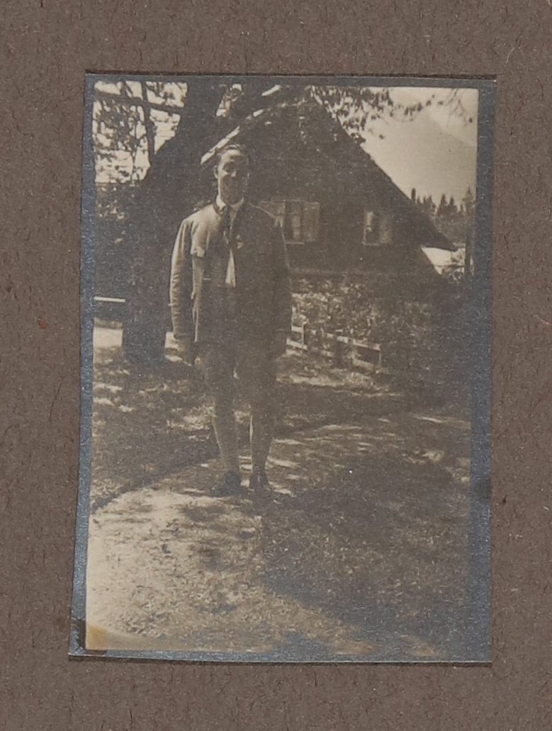 Heinrich Zimmer steht in Lederhose und Tracht vor einem Holzhaus in den Bergen (Vera Graaf CC BY-NC-SA)