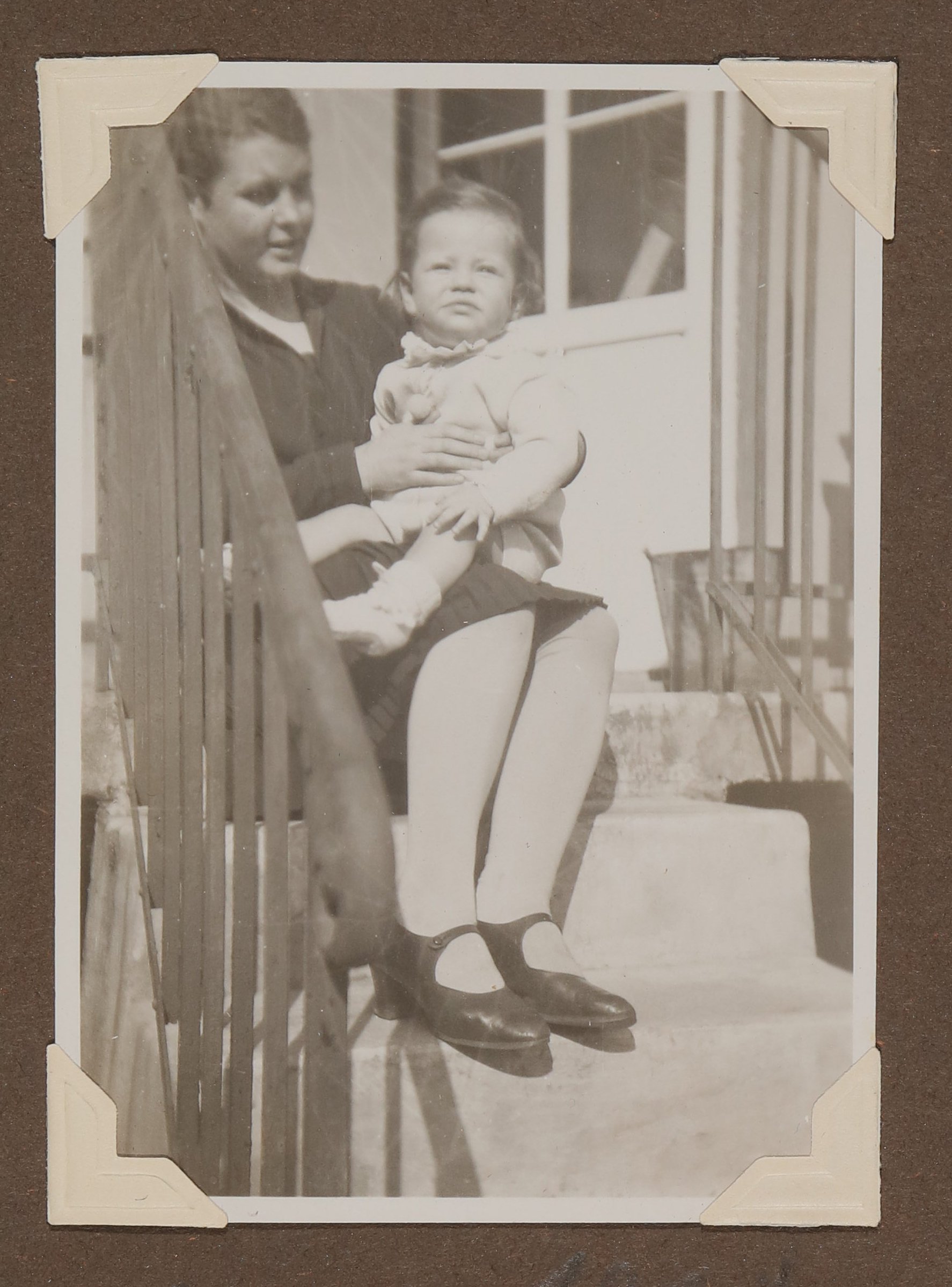 Eine dunkelhaarige Frau sitzt auf Treppenstufen und hält Christiane Zimmers Sohn Christoph auf dem Schoss (Vera Graaf CC BY-NC-SA)