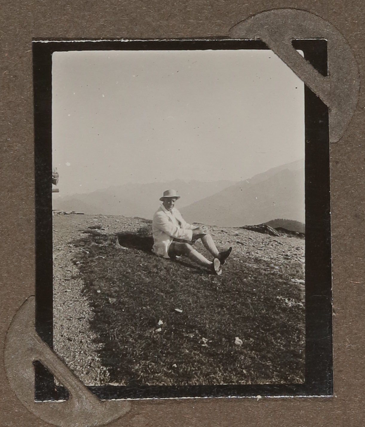 Heinrich Zimmer mit Hut auf einer Wiese in den Bergen sitzend (Vera Graaf CC BY-NC-SA)