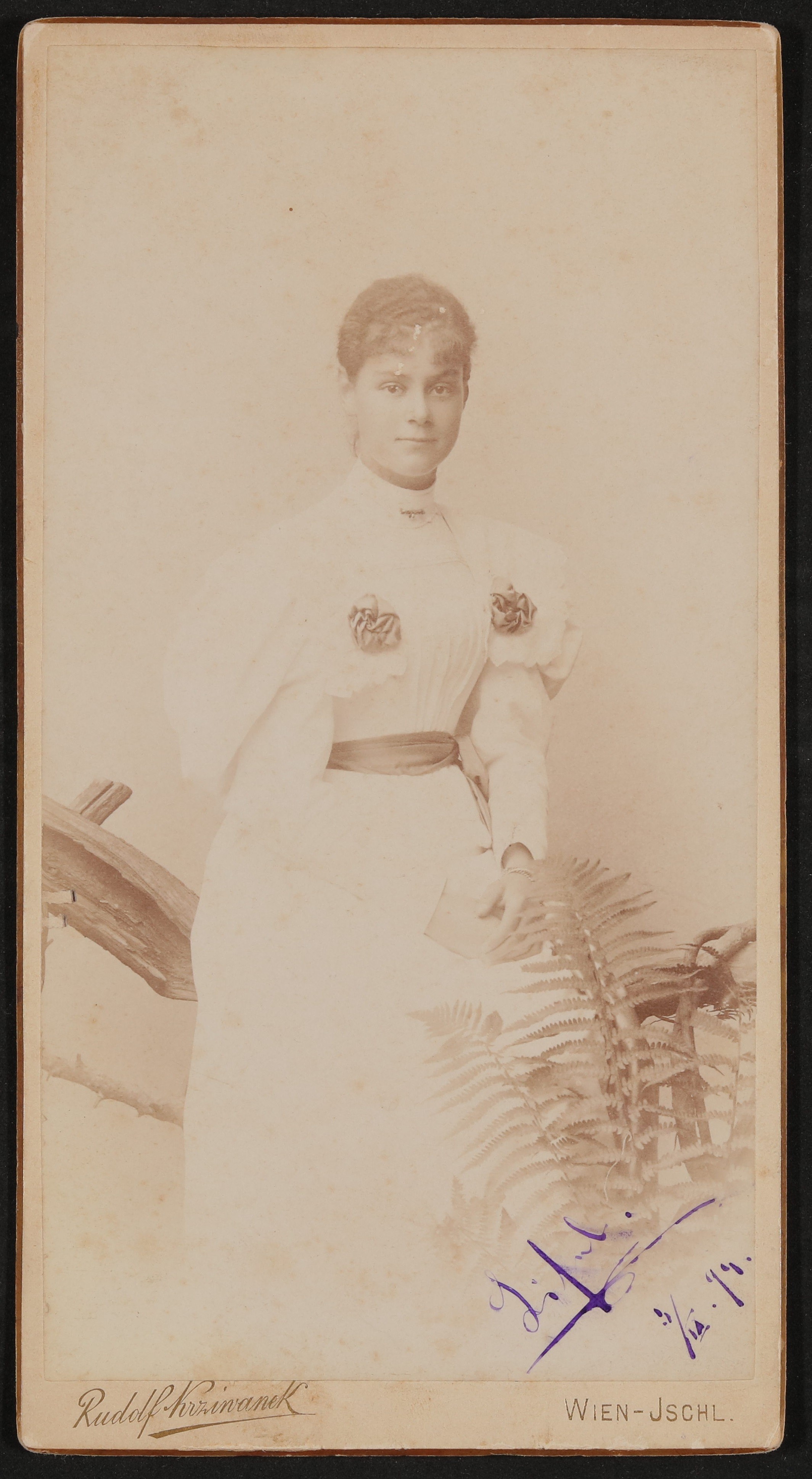 Elisabeth (Lisl) Nicolics im weißen Kleid, an ein Holzgeländer lehnend, davor ein Farn, mit Widmung (Freies Deutsches Hochstift / Frankfurter Goethe-Museum CC BY-NC-SA)