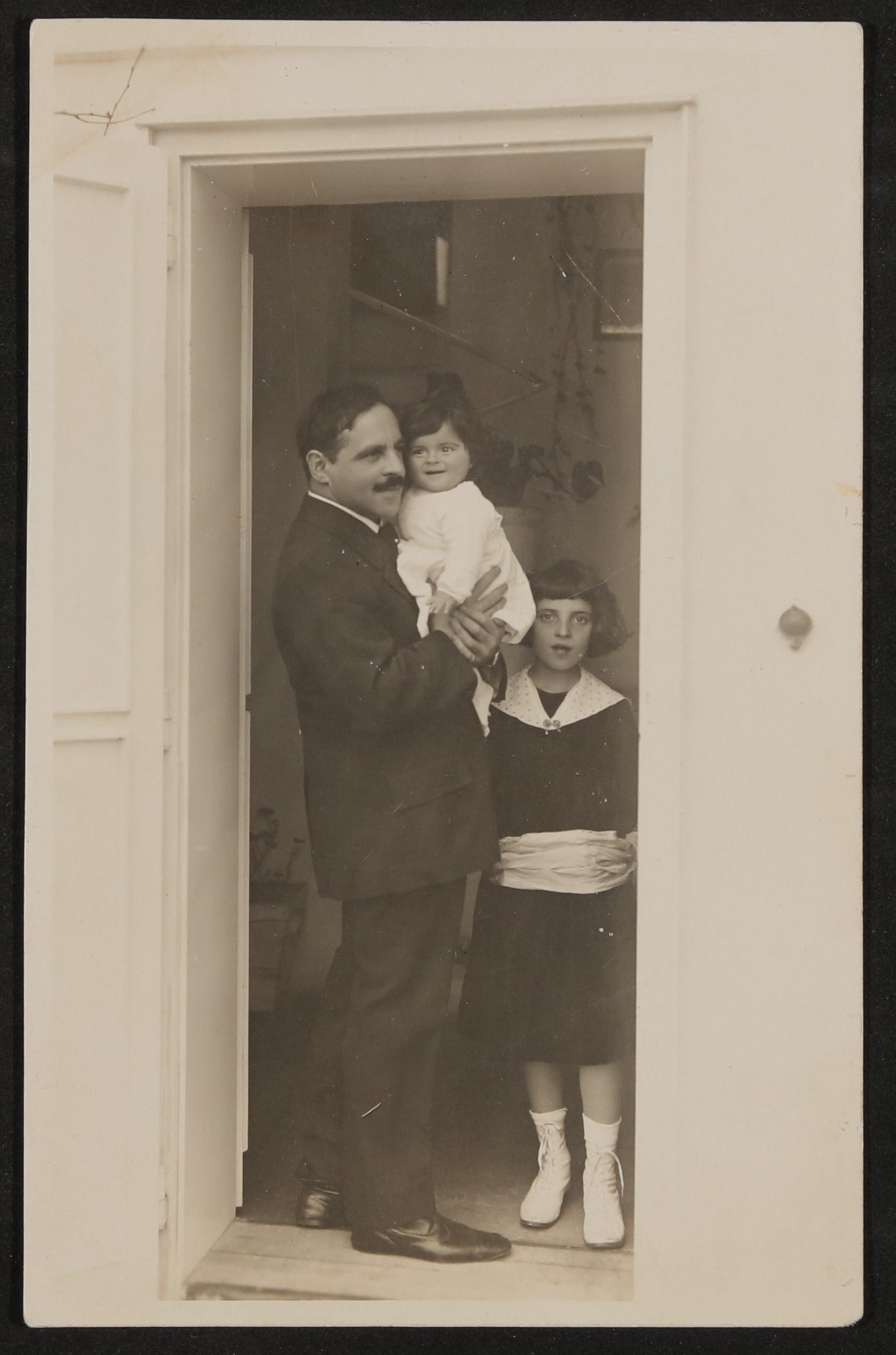 Jakob Wassermann steht im Türrahmen mit seinen Töchtern Judith und Eva (Freies Deutsches Hochstift / Frankfurter Goethe-Museum CC BY-NC-SA)