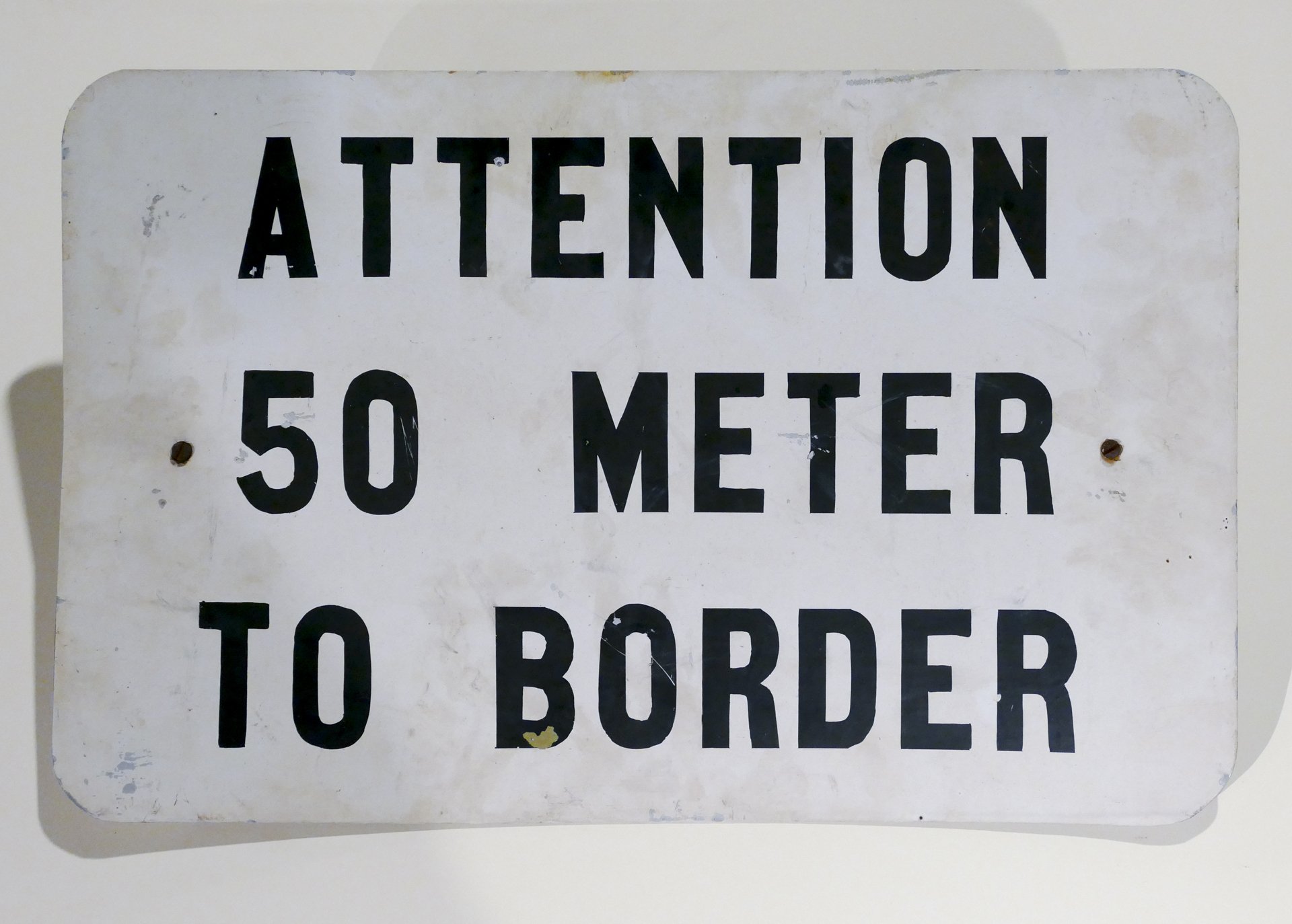 Schild "ATTENTION 50 METER TO BORDER" (Stadtmuseum Kassel CC BY-NC-SA)