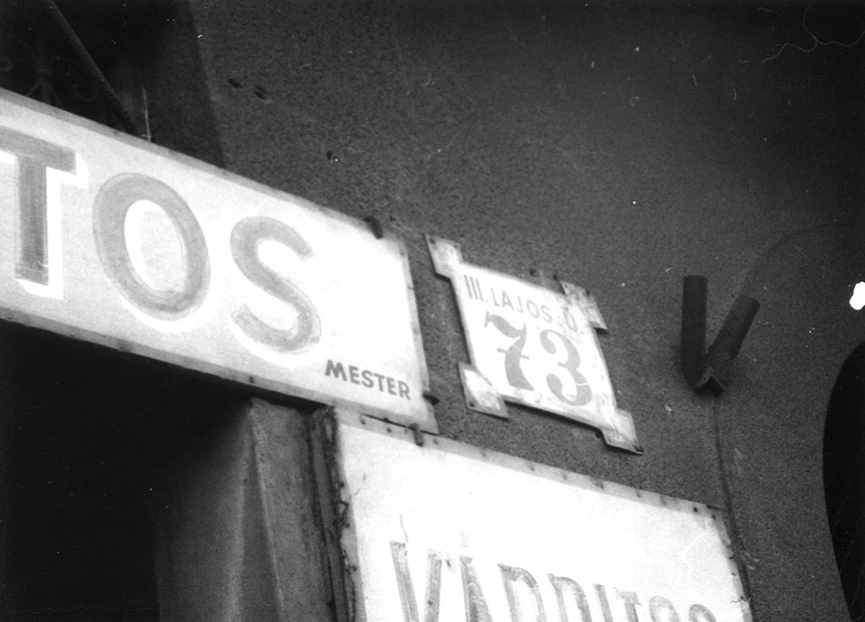 Épület homlokzata cégtáblákkal és utcatáblával (Óbudai Múzeum CC BY-NC-SA)