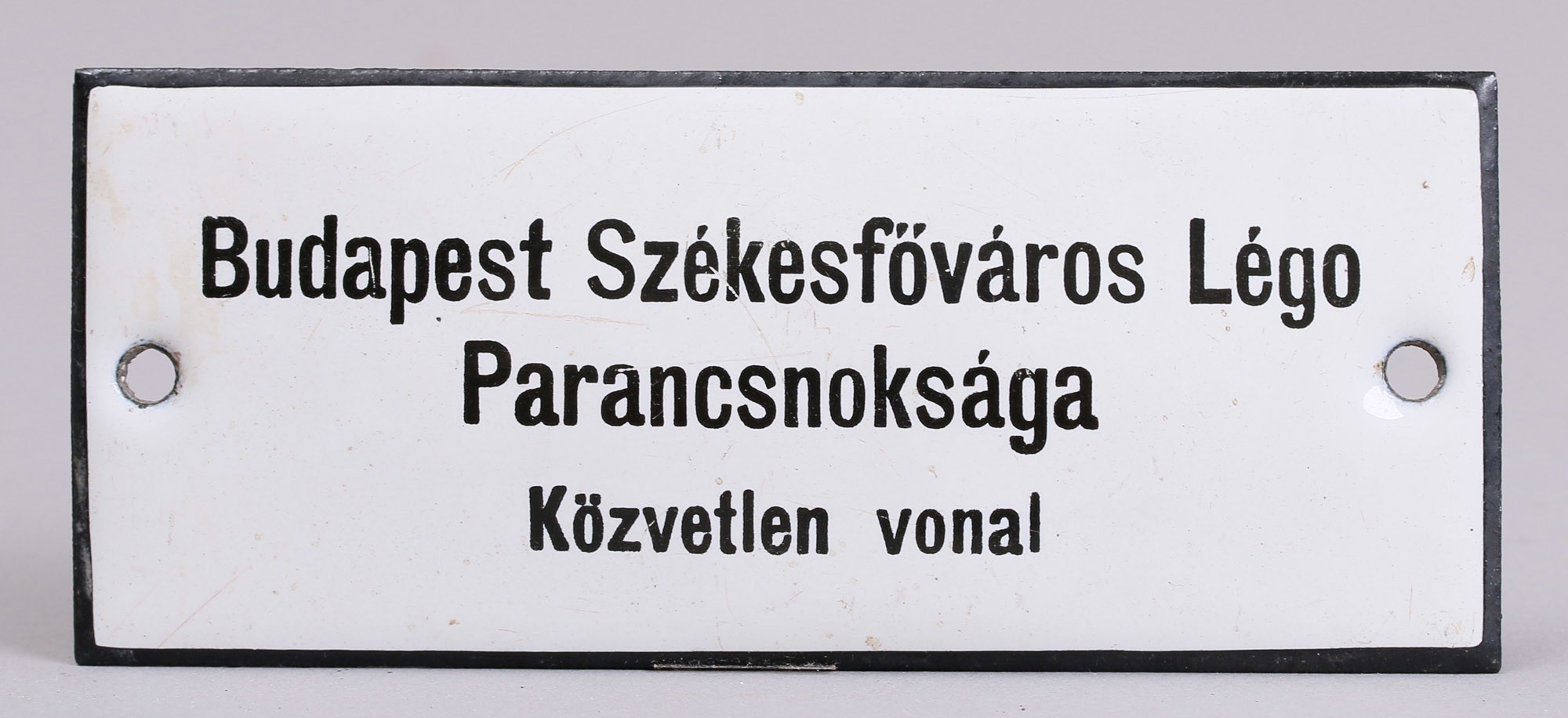 Zománcozott tábla „BUDAPEST SZÉKESFŐVÁROS LÉGÓ PARANCSNOKSÁGA KÖZVETLEN VONAL” (Postamúzeum CC BY-NC-SA)