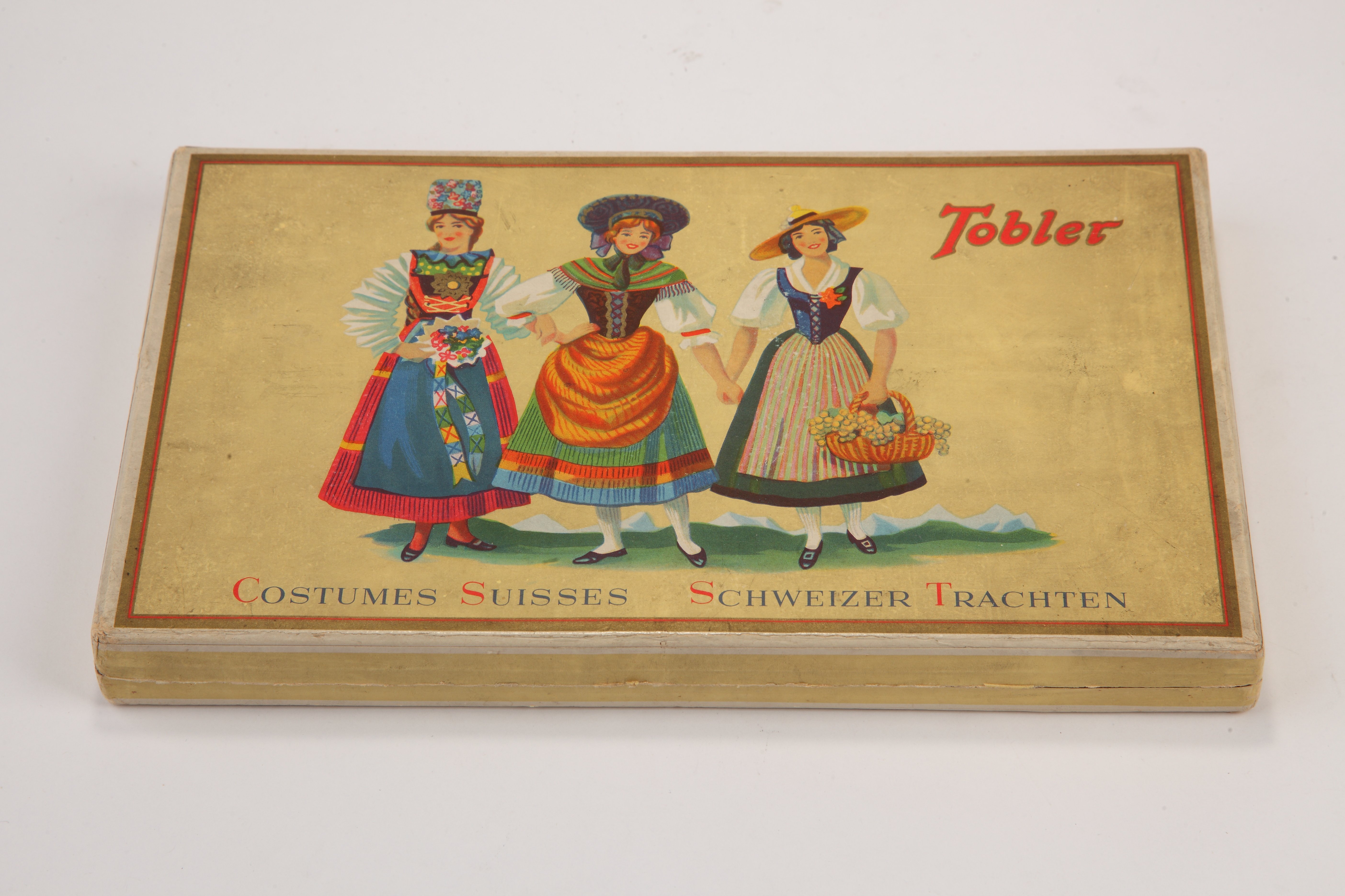 Tobler papírdoboz fedelén és a doboz belsejében három svájci népviseletbe öltözött leány (Magyar Kereskedelmi és Vendéglátóipari Múzeum CC BY-NC-SA)