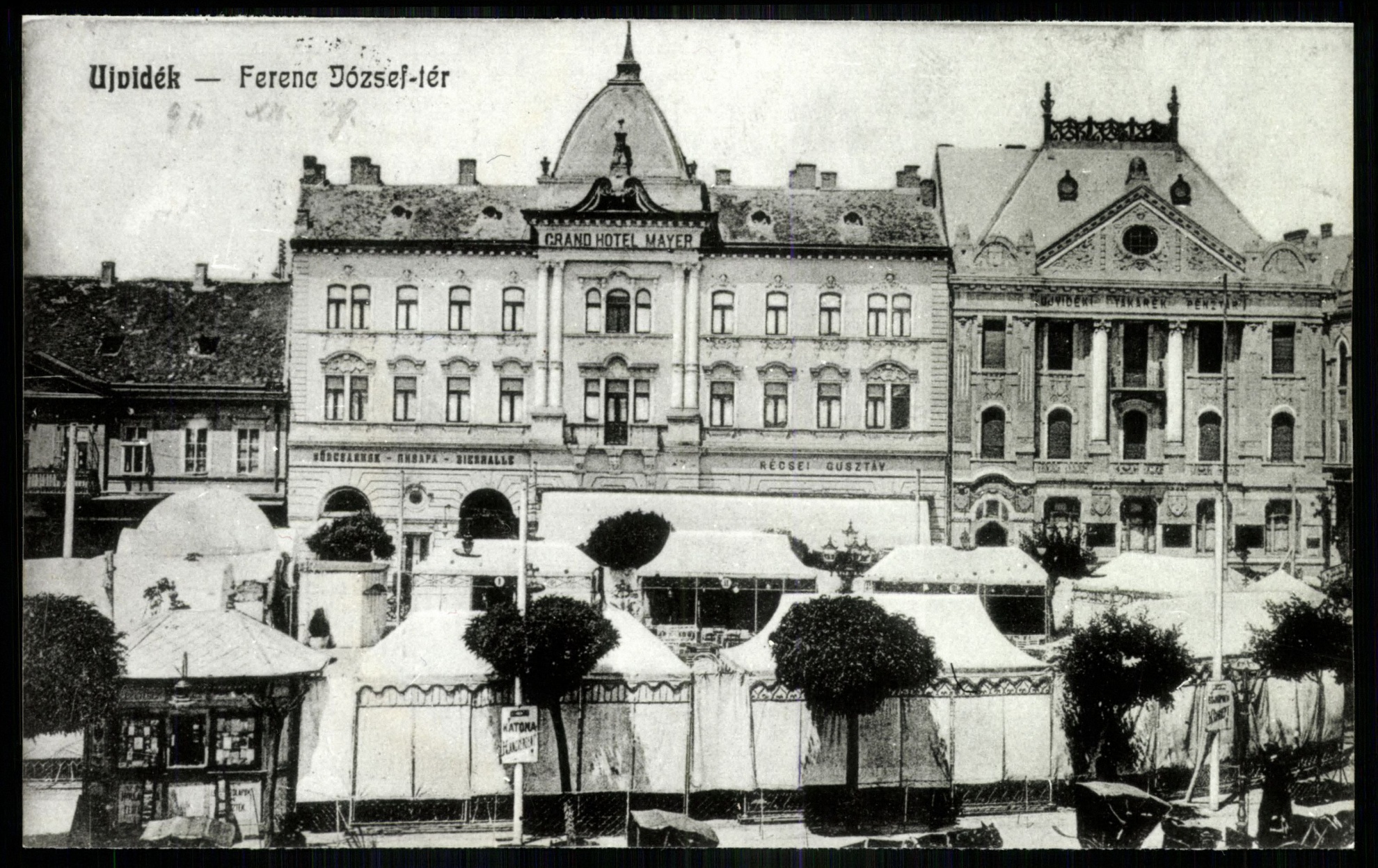 Újvidék Ferenc József tér. Grand Hotel Mayer (elől, fán táblaL Katona hangverseny) (Magyar Kereskedelmi és Vendéglátóipari Múzeum CC BY-NC-ND)