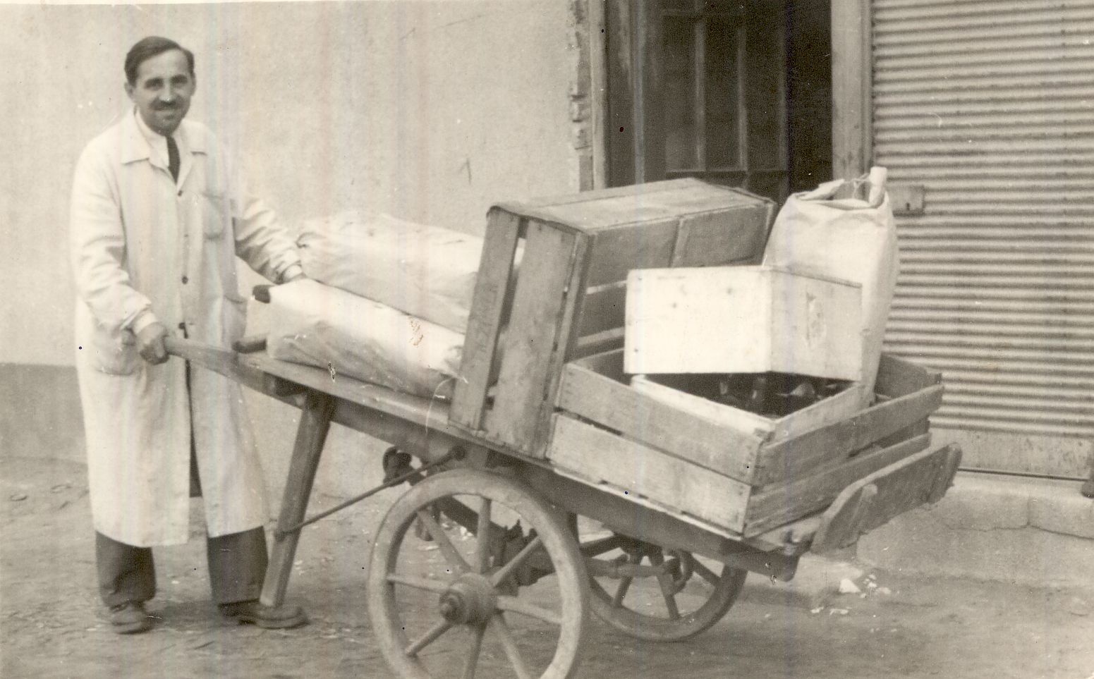 Egy kereskedő kétkerekű taligán árut tol Budapest XX. század első fele (Magyar Kereskedelmi és Vendéglátóipari Múzeum CC BY-NC-ND)