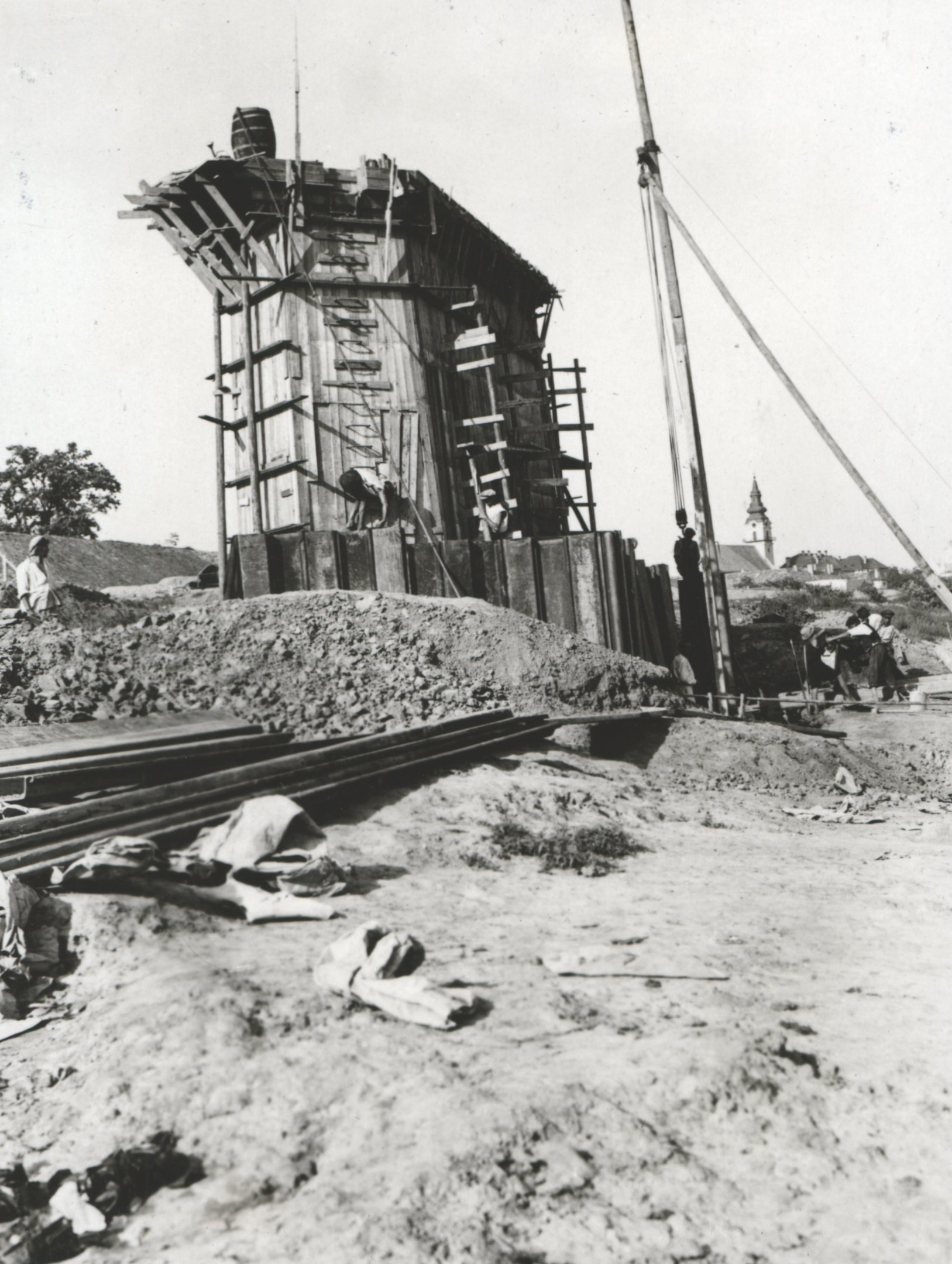 Larsen-vasszádpallók kihúzása emelő bikával a bebetonozott pillér mögött. Jól látható a pillér hágcsója, 1934. augusztus 23. (Magyar Környezetvédelmi és Vízügyi Múzeum - Duna Múzeum CC BY-NC-SA)