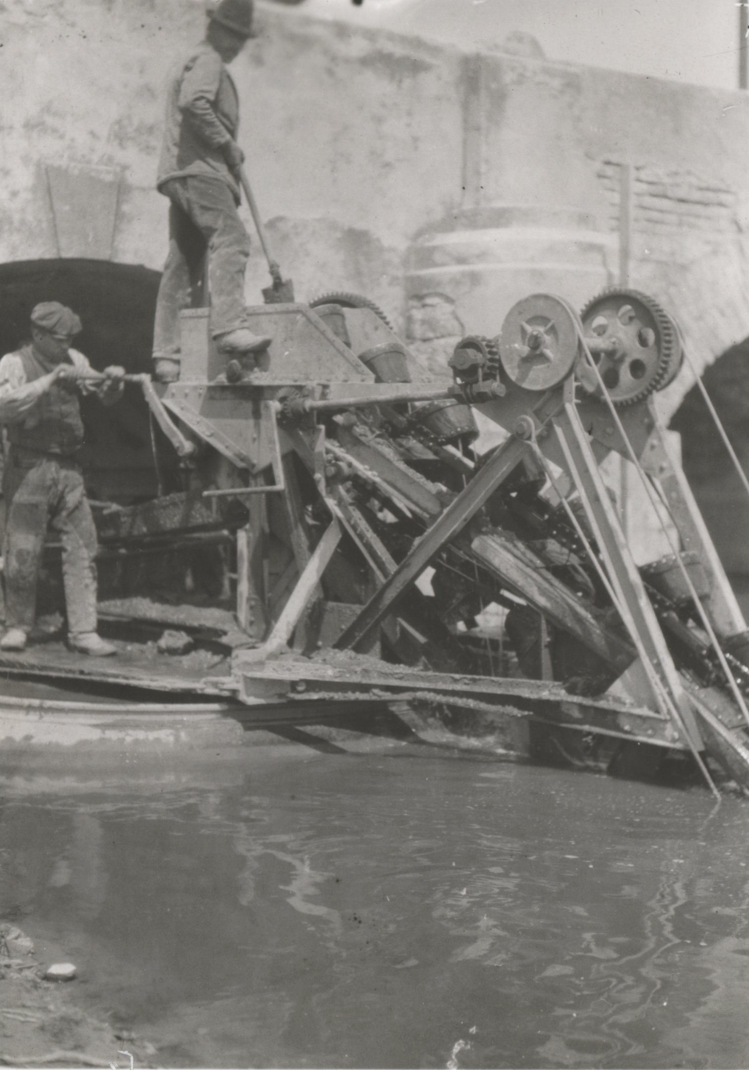 Kézi hajtású úszókotró-gép a fülöpszállási kétnyílású boltozott közúti híd alatt kotor (Magyar Környezetvédelmi és Vízügyi Múzeum - Duna Múzeum CC BY-NC-SA)
