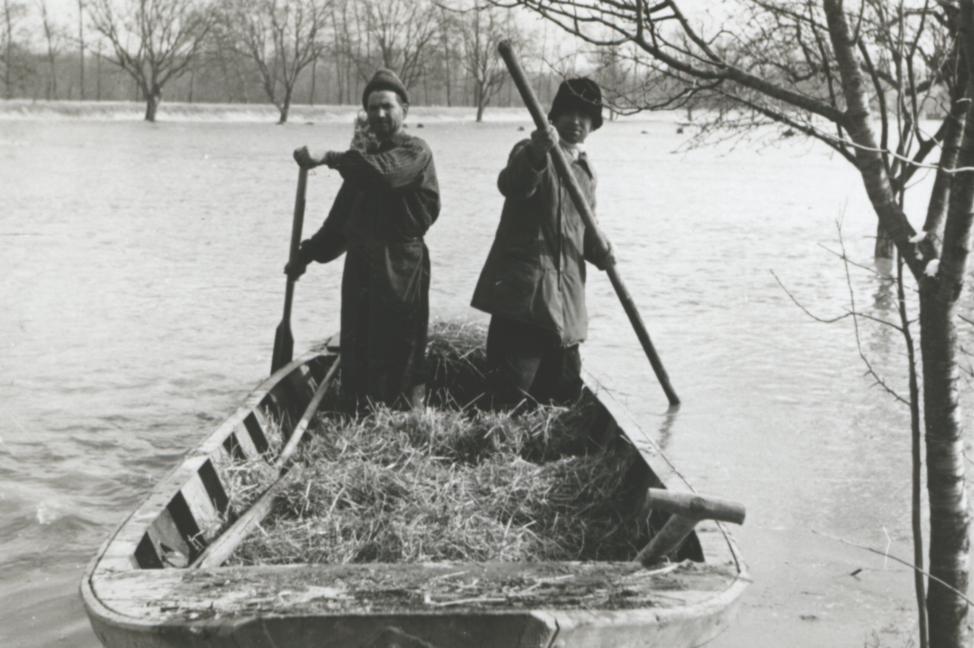 A víz által körülzárt műszakiak árvízvédelmi ladikon elhagyják a védvonalat a doromlási alvó gát mentén (Magyar Környezetvédelmi és Vízügyi Múzeum - Duna Múzeum CC BY-NC-SA)