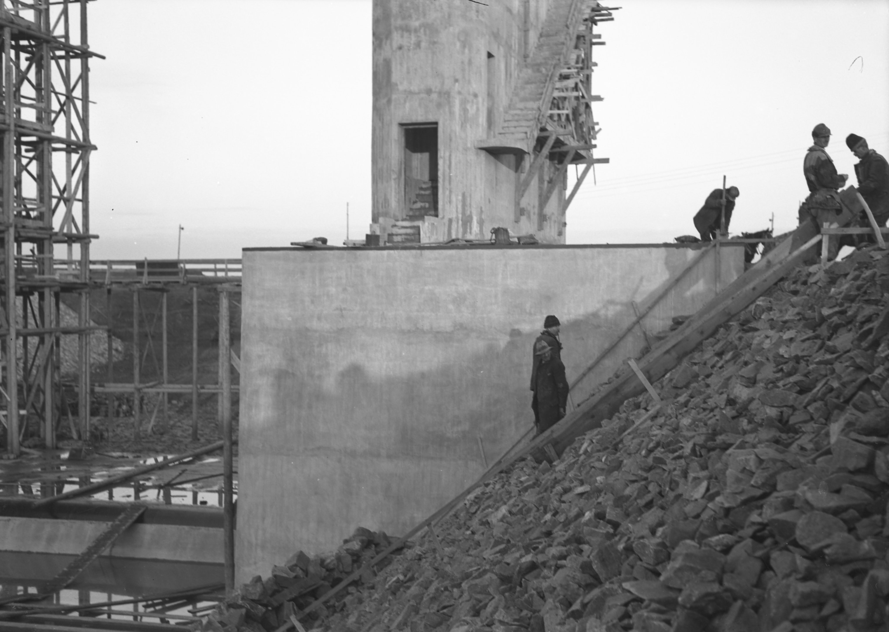 Alapkőterítés a pillér homlokfala mellett feltöltött rézsűn, 1938. december 8. (Magyar Környezetvédelmi és Vízügyi Múzeum - Duna Múzeum CC BY-NC-SA)