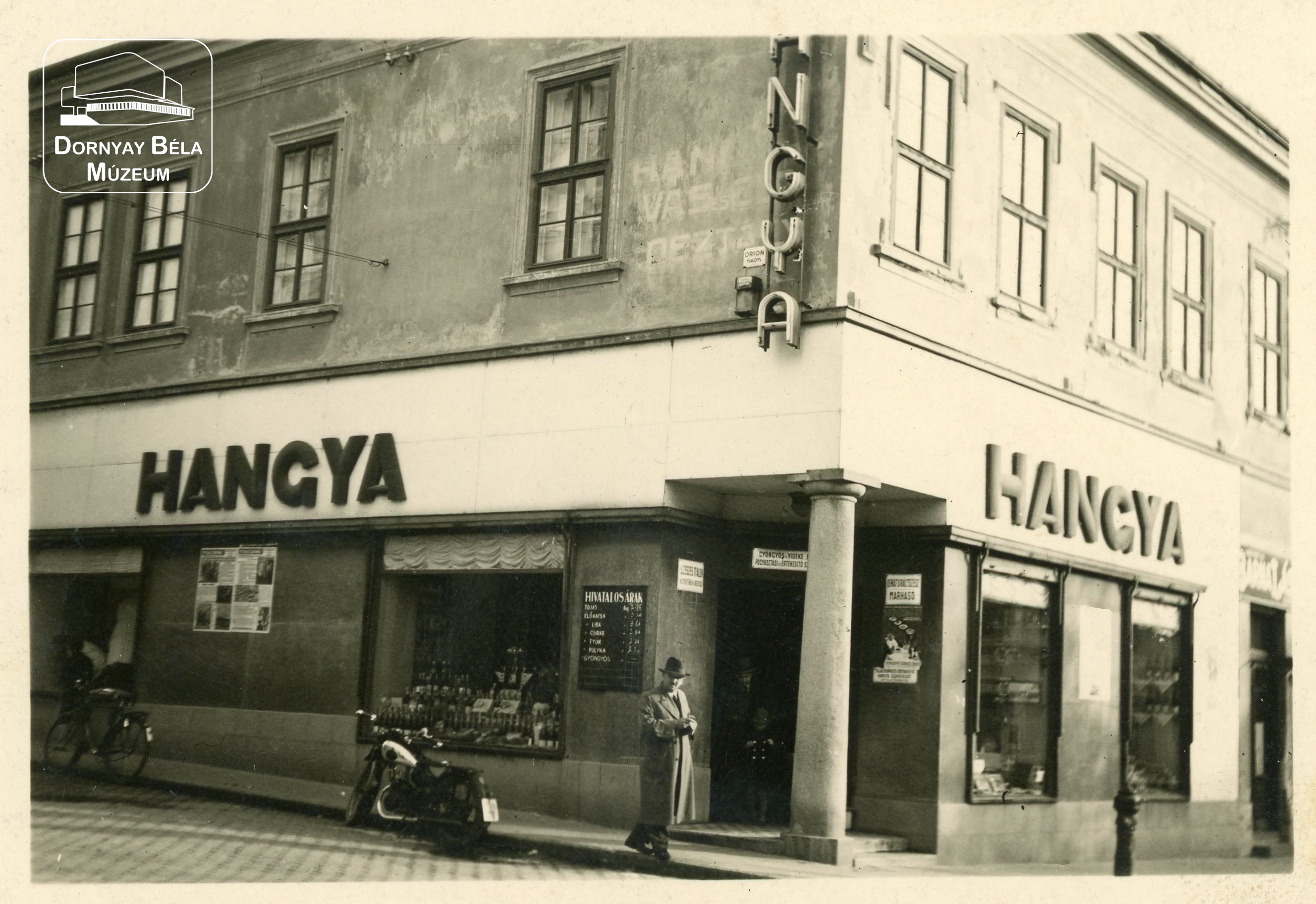 Gyöngyösi Hangya épülete, előtte Csekey László, motorkerékpárjával. (Dornyay Béla Múzeum, Salgótarján CC BY-NC-SA)