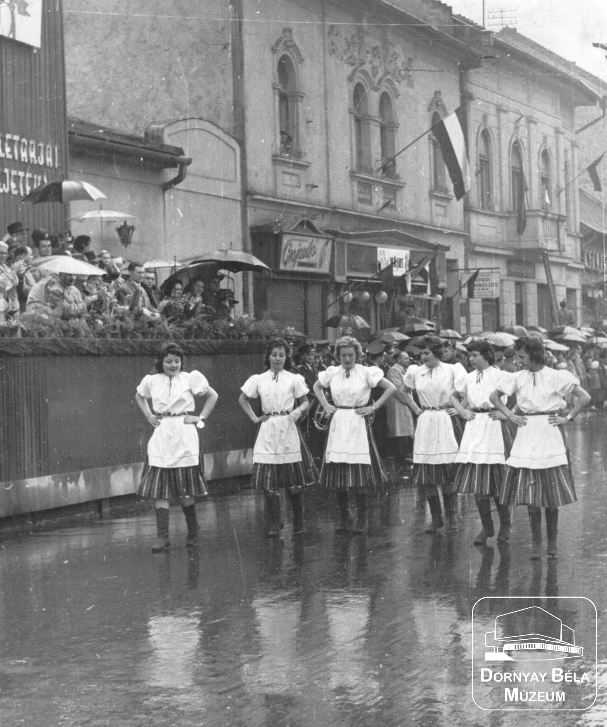 Népviseletbe öltözött lányok május 1-i felvonuláson, a Rákóczi úton, a tribün előtt (Dornyay Béla Múzeum, Salgótarján CC BY-NC-SA)