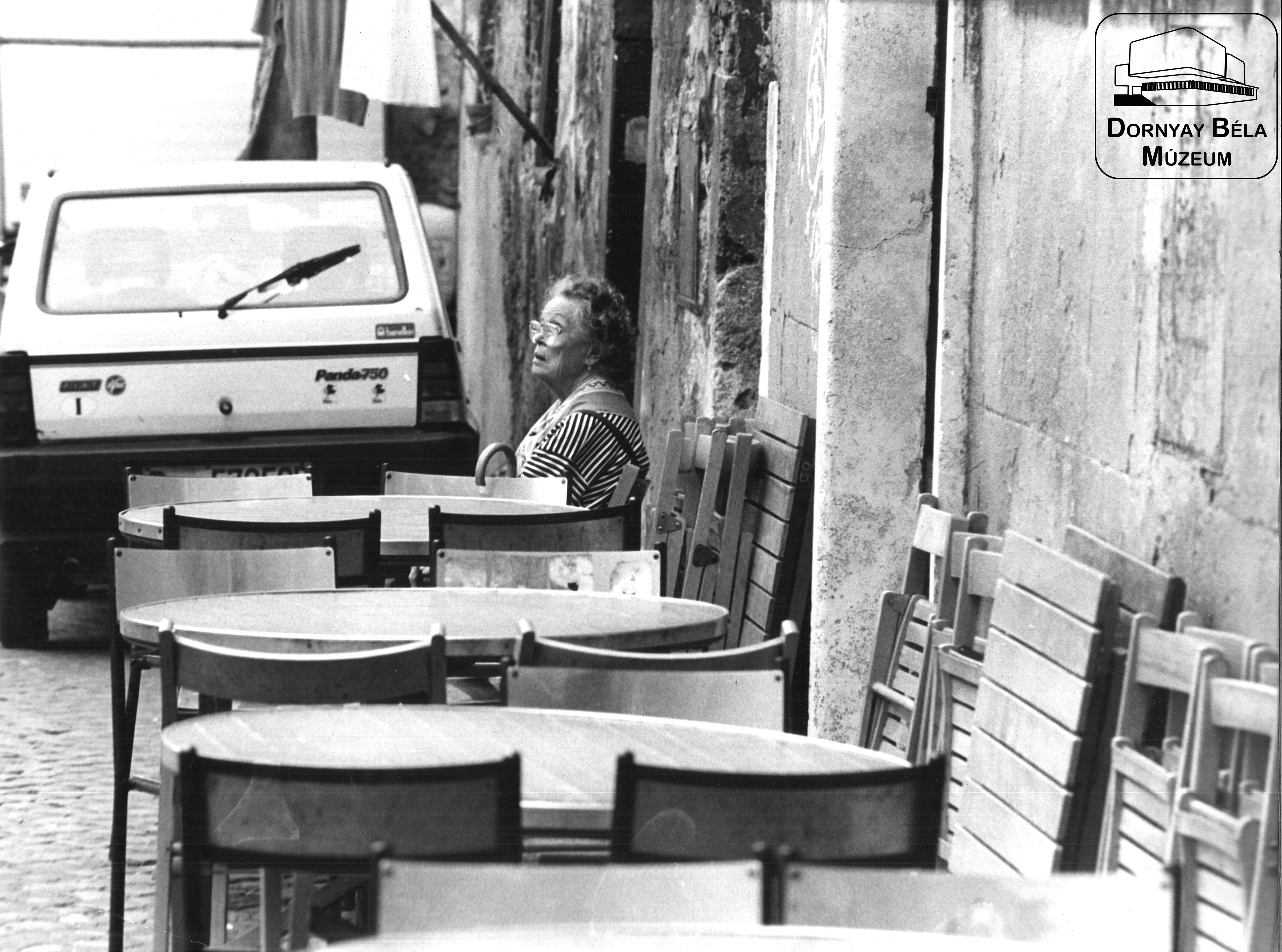 "Idős nő asztalokkal, székekkel" (Dornyay Béla Múzeum, Salgótarján CC BY-NC-SA)