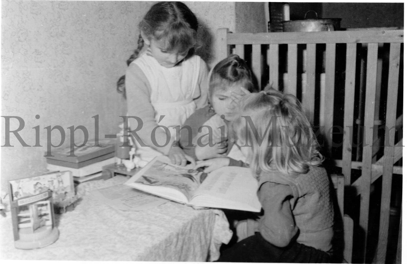 Délelőtti játék a darányi óvodában. Három kislány könyvet nézeget (Rippl-Rónai Múzeum CC BY-NC-SA)