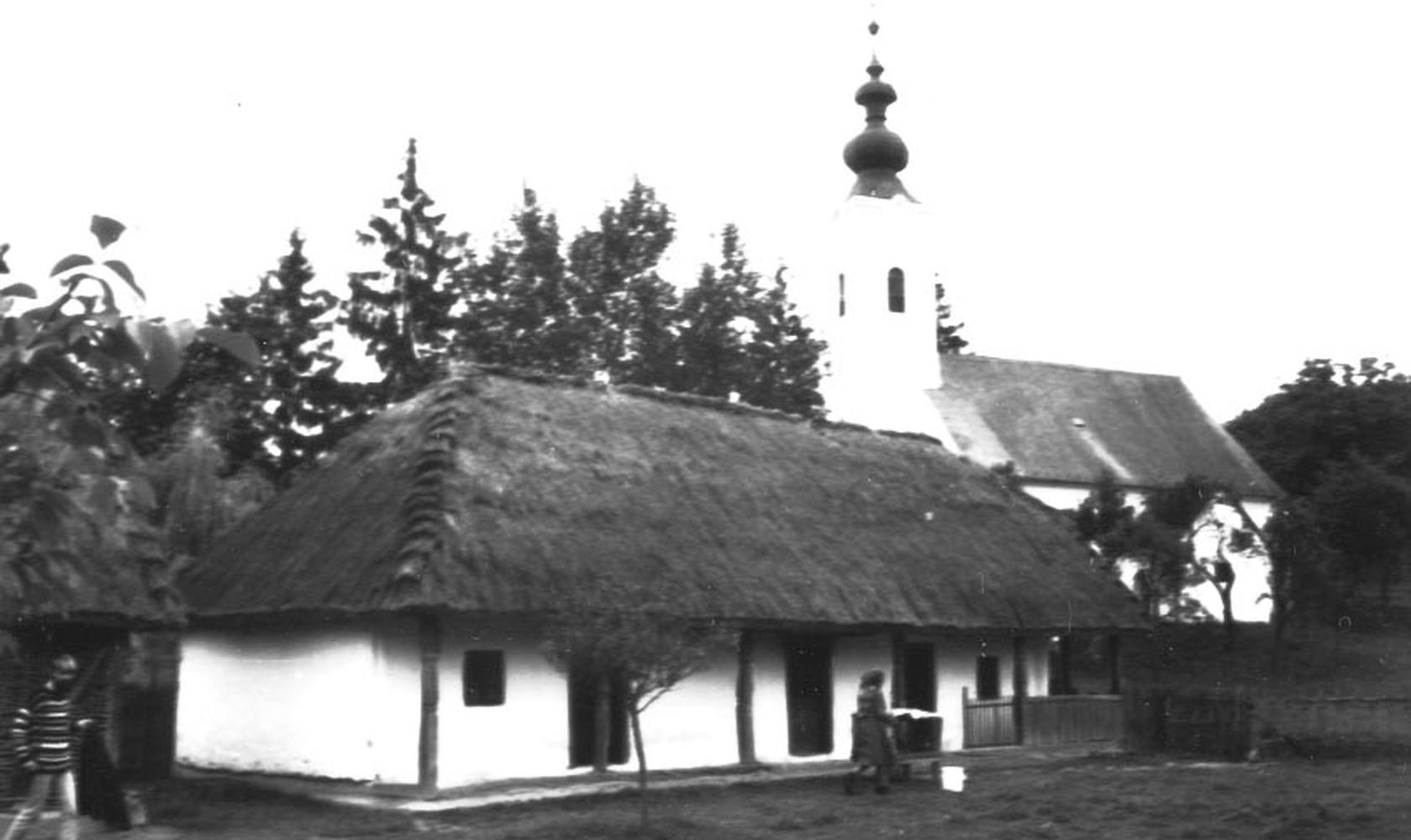 A rinyakovácsi lakóház látképe a templommal (Rippl-Rónai Múzeum CC BY-NC-ND)