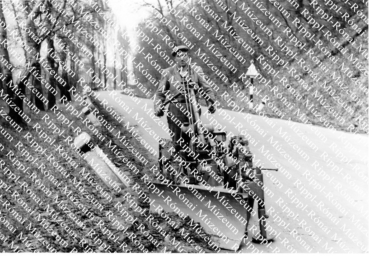 A 7-es országúton Pintér Sándor útőr az útpadkát gyalulja (Rippl-Rónai Múzeum CC BY-NC-SA)
