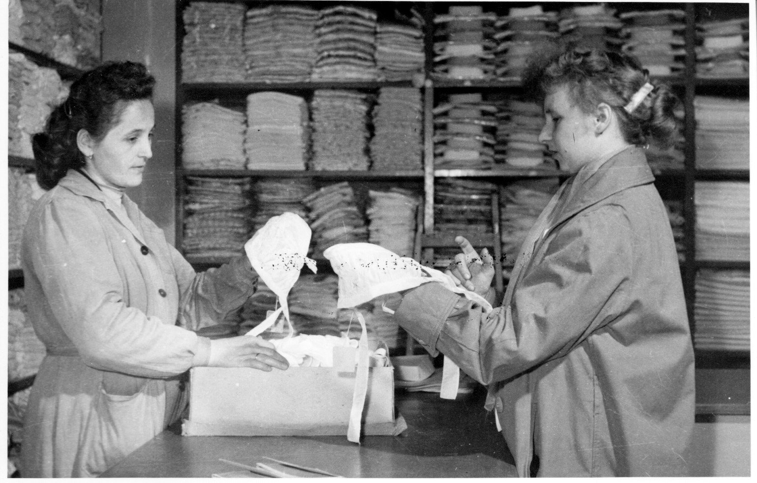 Takács Józsefné, a marcali Vegyesruházati bolt eladója segít Zentai Tibornénak a sapkavásárlásban (Rippl-Rónai Múzeum CC BY-NC-SA)