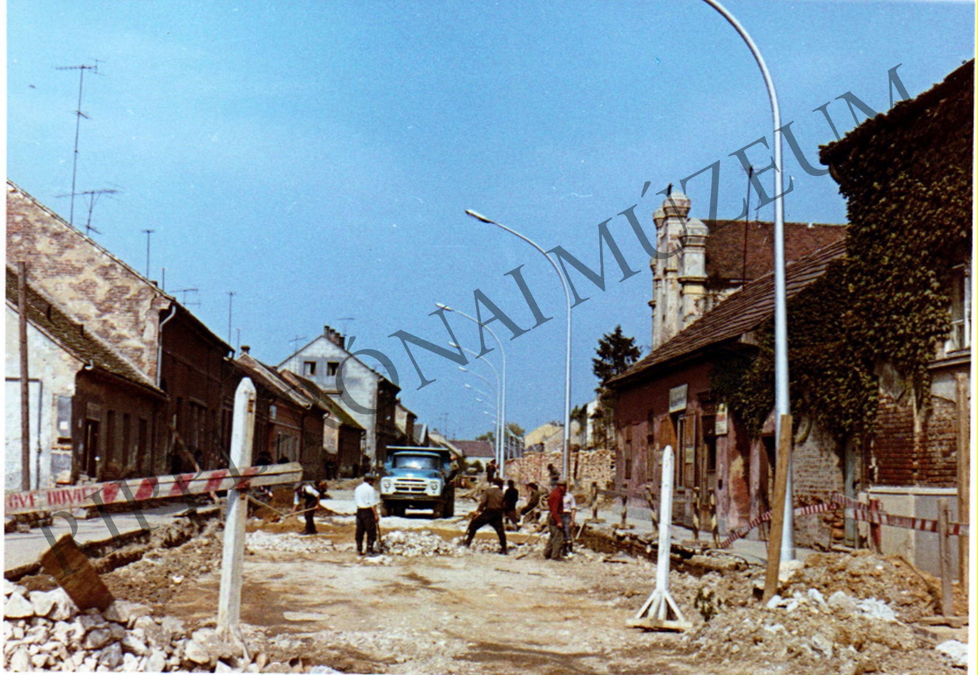 A kaposvári Berzsenyi utca a Zsinagógával. A gázcsövek fekteése miatt romos az utcakép (Rippl-Rónai Múzeum CC BY-NC-SA)
