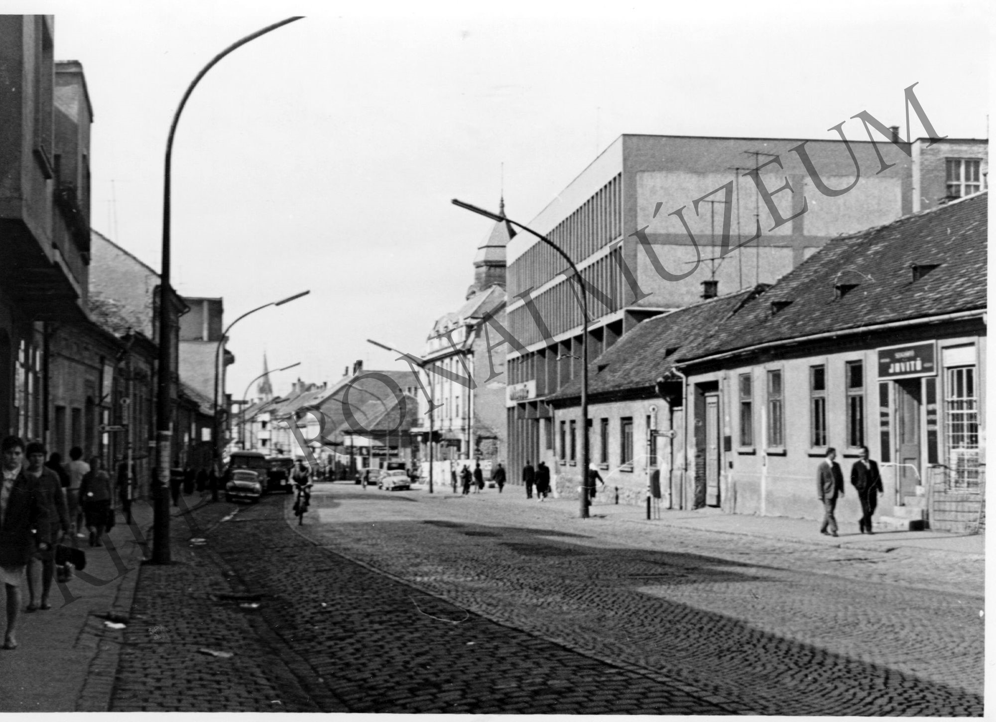 A kaposvári Május 1. (ma Fő) utca. Háttérben a Ruhagyár és a Béke Szálló (ma: Hotel Dorottya) (Rippl-Rónai Múzeum CC BY-NC-SA)