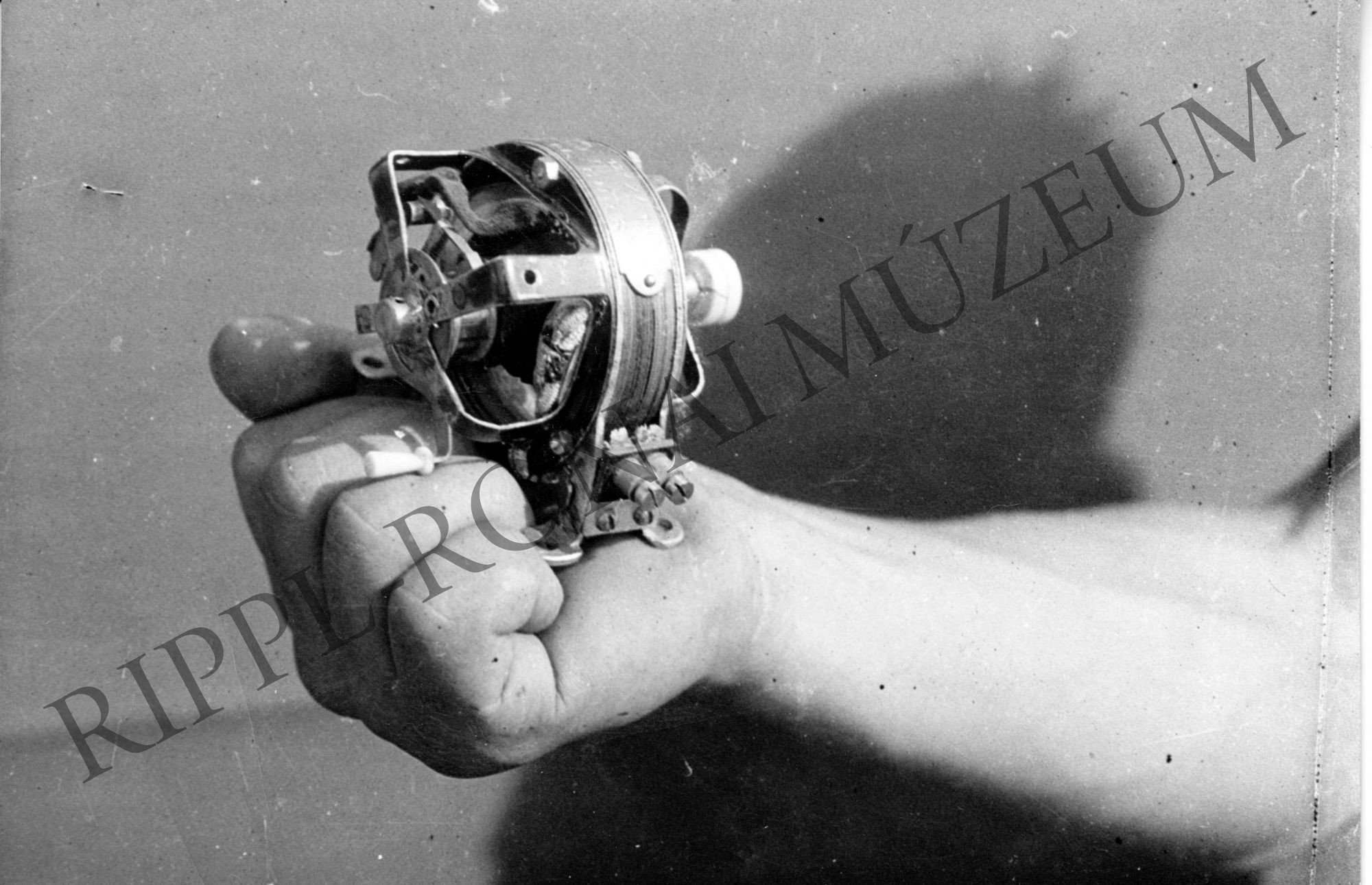 Balogh István keze, benne a villanymotor modellje a Gurs-i tábor kiállításán (Rippl-Rónai Múzeum CC BY-NC-SA)