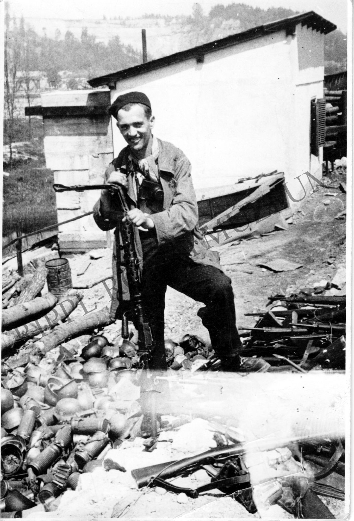 Francisco (Paco) Boix, a mauthauseni láger fotósa az SS-ektől elvett fegyvereket ellenőrzi (Rippl-Rónai Múzeum CC BY-NC-SA)
