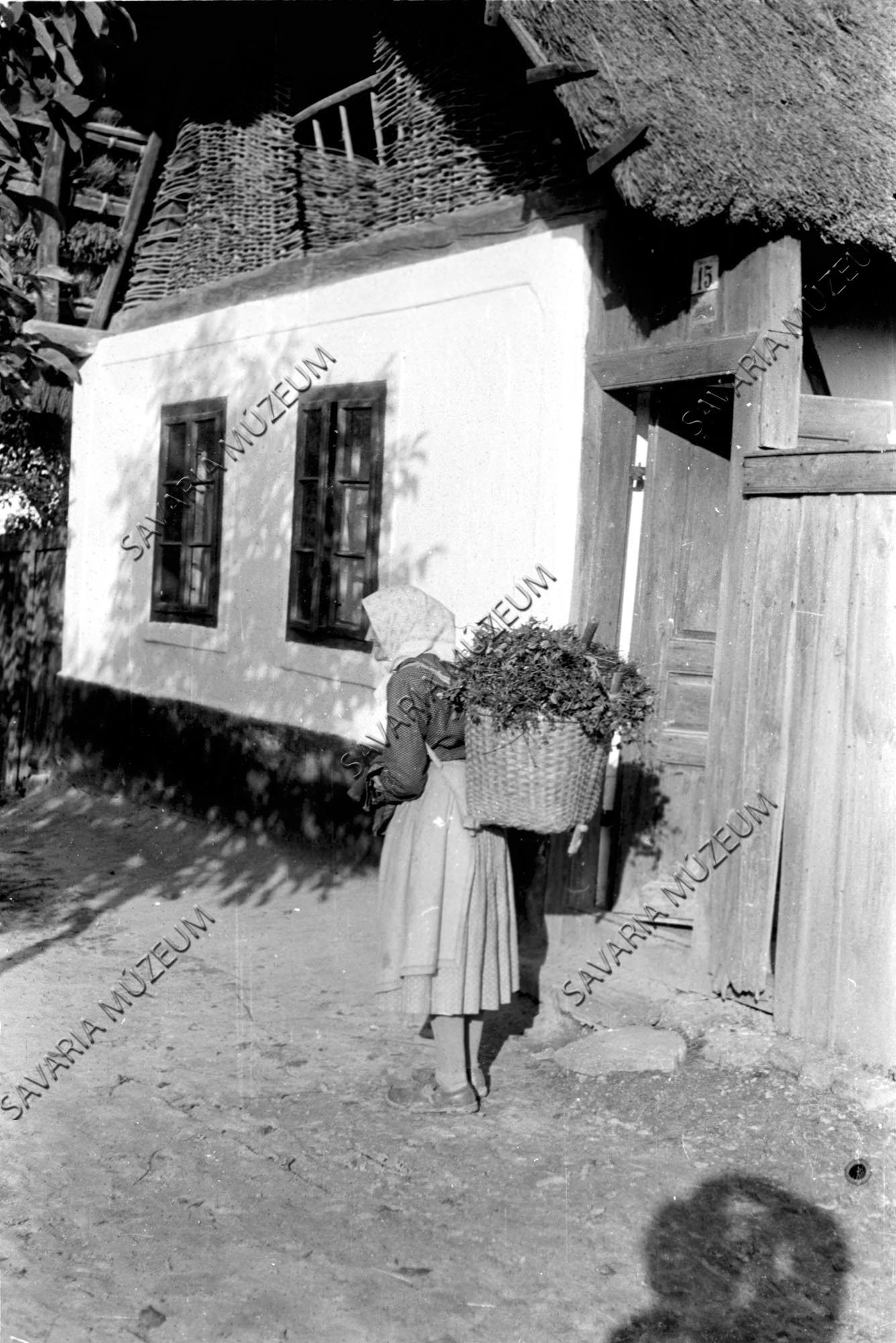Házhomlokzat és asszony hátaskosárral (Savaria Megyei Hatókörű Városi Múzeum, Szombathely CC BY-NC-SA)
