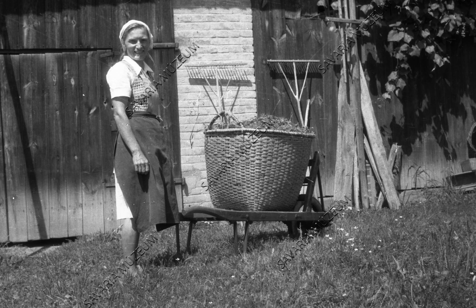 Asszony talicskával, abrakos kosárral és gereblyék (Savaria Megyei Hatókörű Városi Múzeum, Szombathely CC BY-NC-SA)