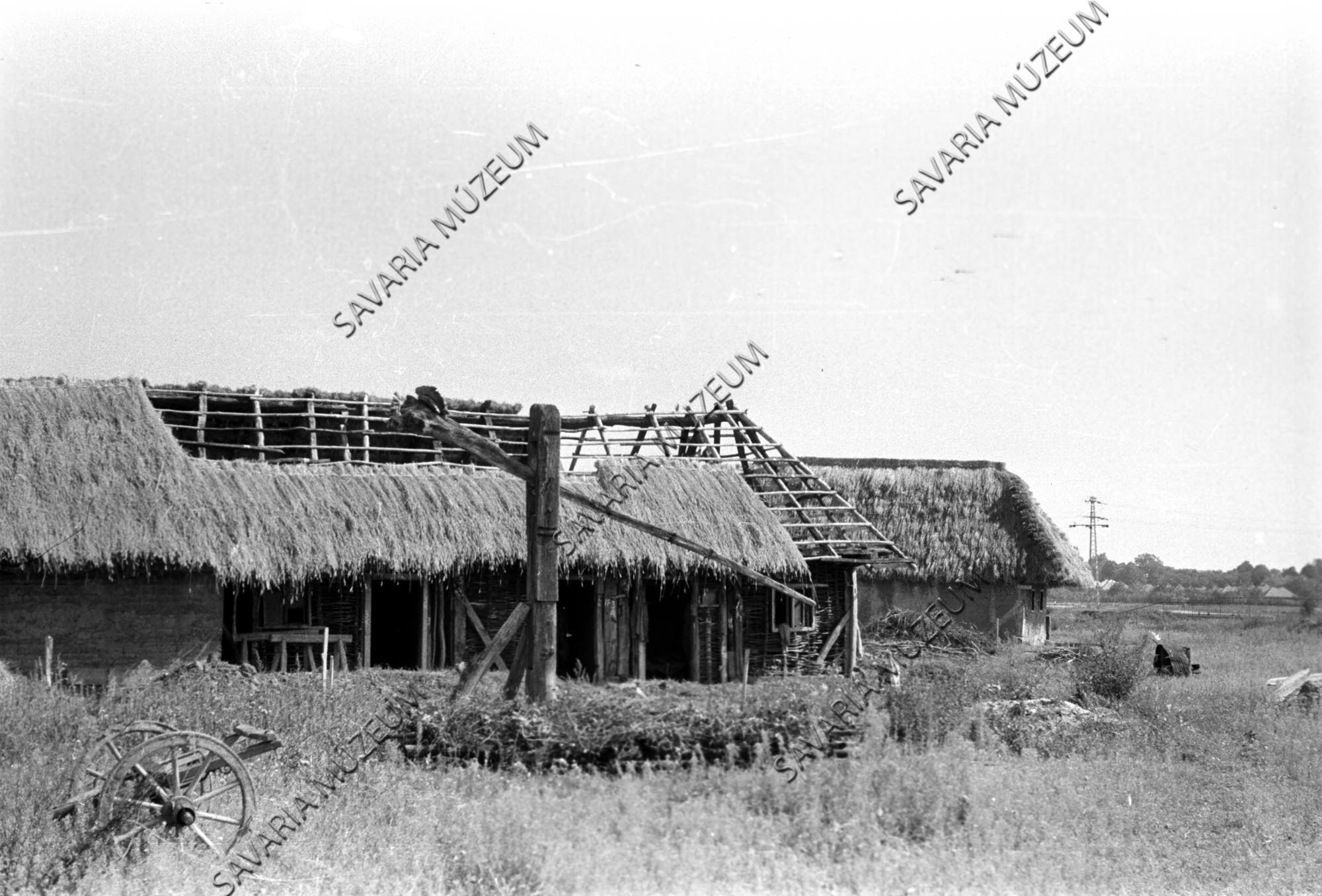 Az épülő nemeskoltai ház és szentpéterfai ház gémeskúttal (Savaria Megyei Hatókörű Városi Múzeum, Szombathely CC BY-NC-SA)
