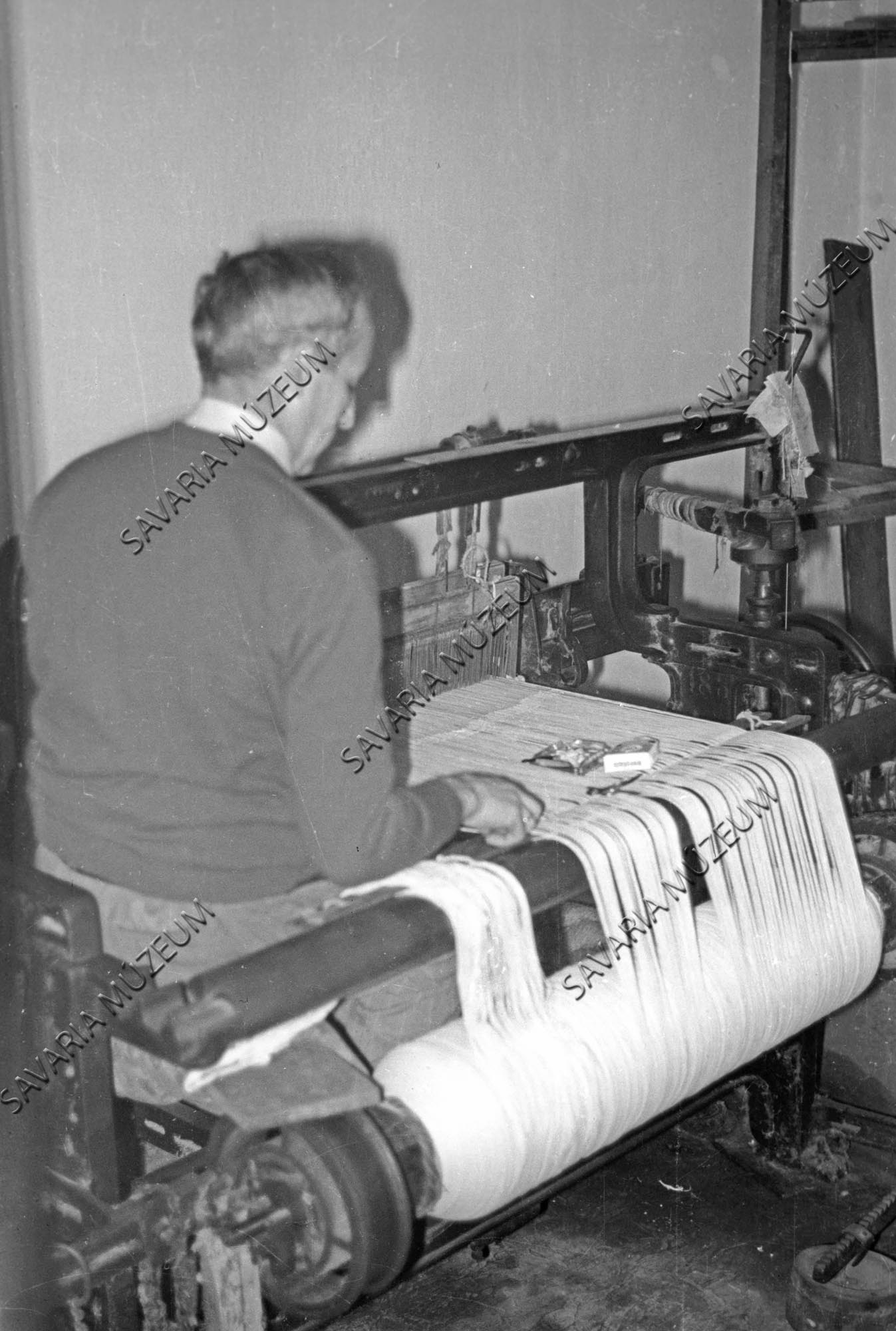 Takács a mechanikai szövőgépen dolgozik (Savaria Megyei Hatókörű Városi Múzeum, Szombathely CC BY-NC-SA)