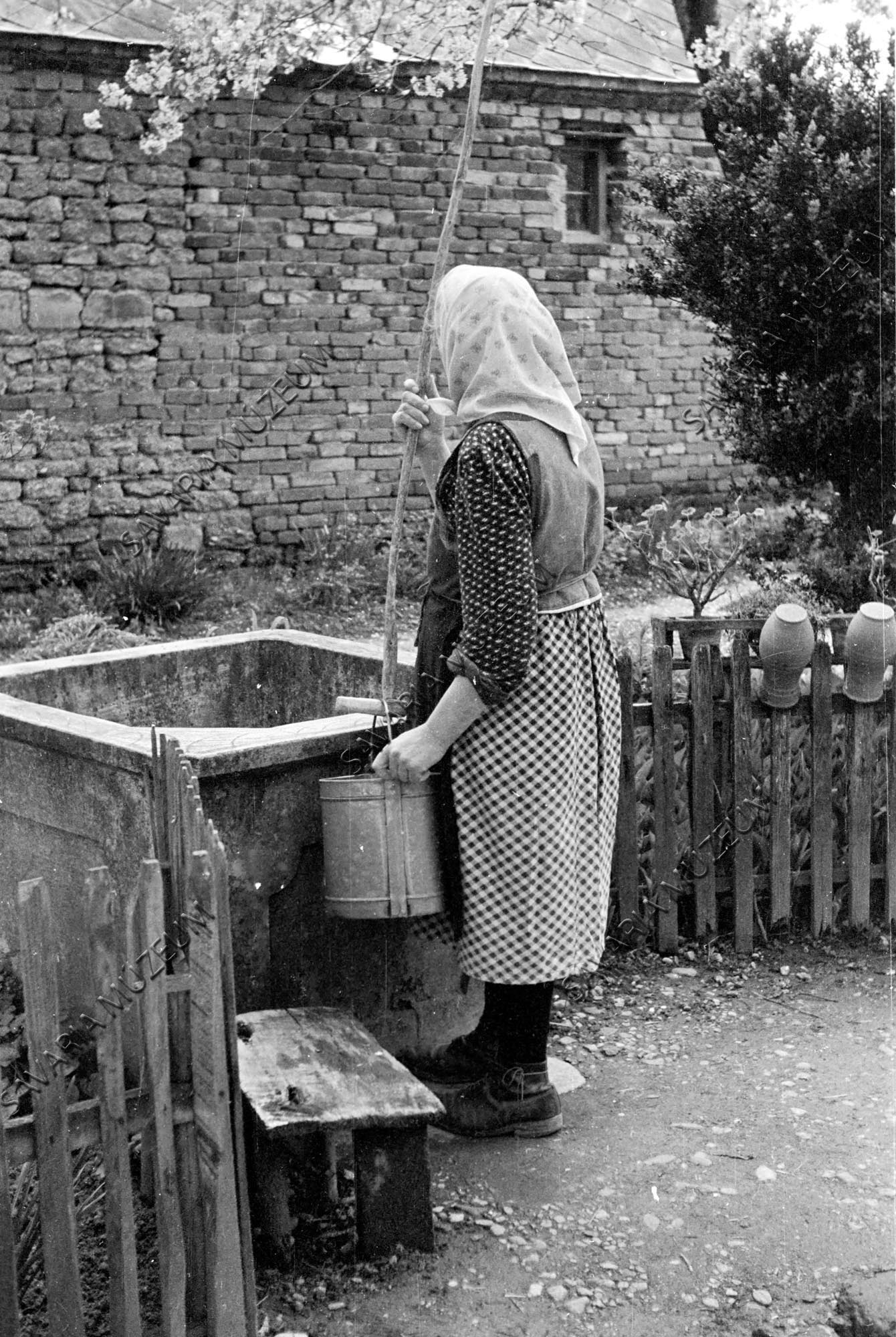 Vízhúzás és tejesfazekak a kerítésen (Savaria Megyei Hatókörű Városi Múzeum, Szombathely CC BY-NC-SA)