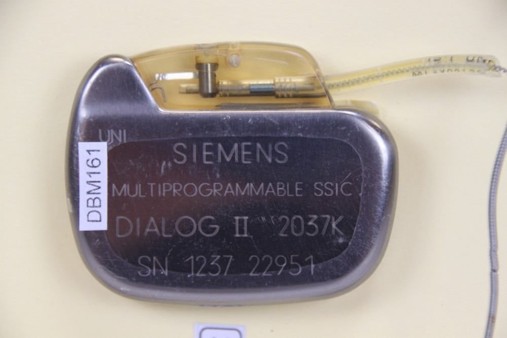 Herzschrittmacher: Siemens Multiprogrammable SSIC Dialog II, SN 1237 22951, Elektrodenkabel kurz. Firmenname Siemens Elema Rückseite (Krankenhausmuseum Bielefeld e.V. CC BY-NC-SA)