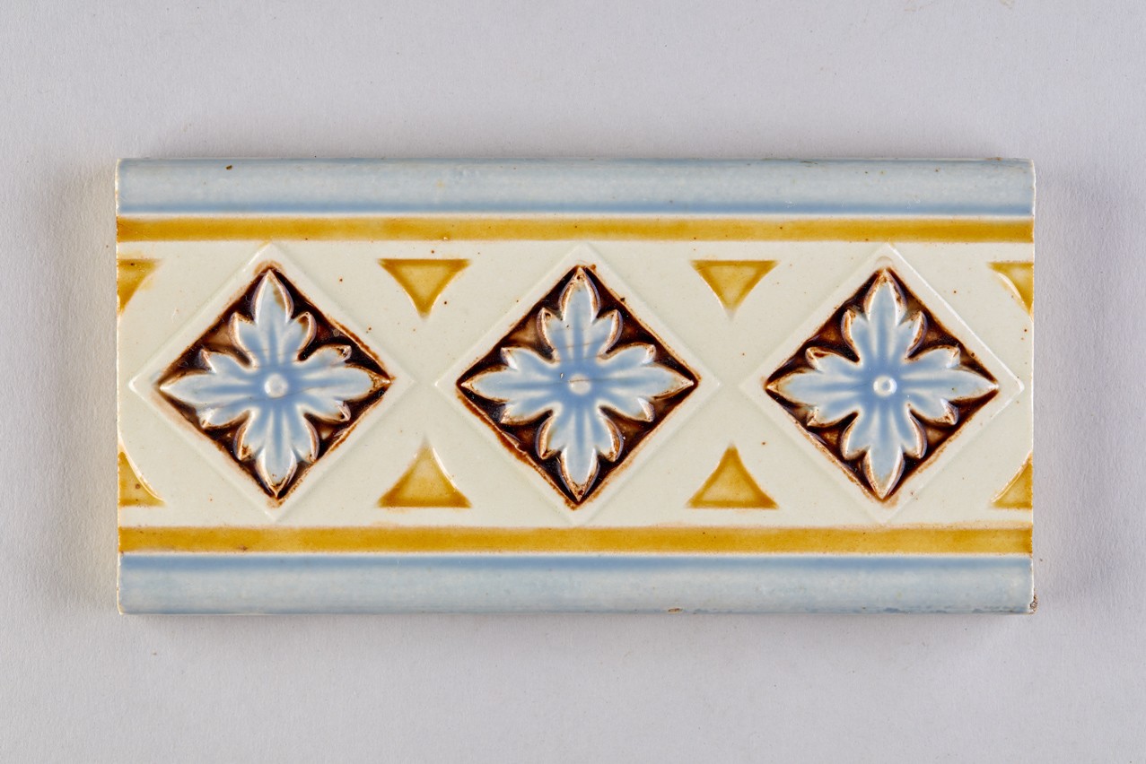 Schmuckband, geometrischer Dekor mit Blüten verziert; Halbfliese (KreisMuseum Zons CC BY-NC-SA)