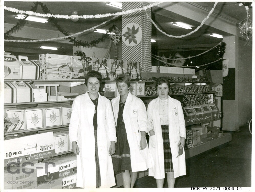 Schwarzweißfoto, Drei Verkäuferin vor einem Verkaufsregal in der BX der Ramstein Air Base ("dc-r" docu center ramstein RR-F)