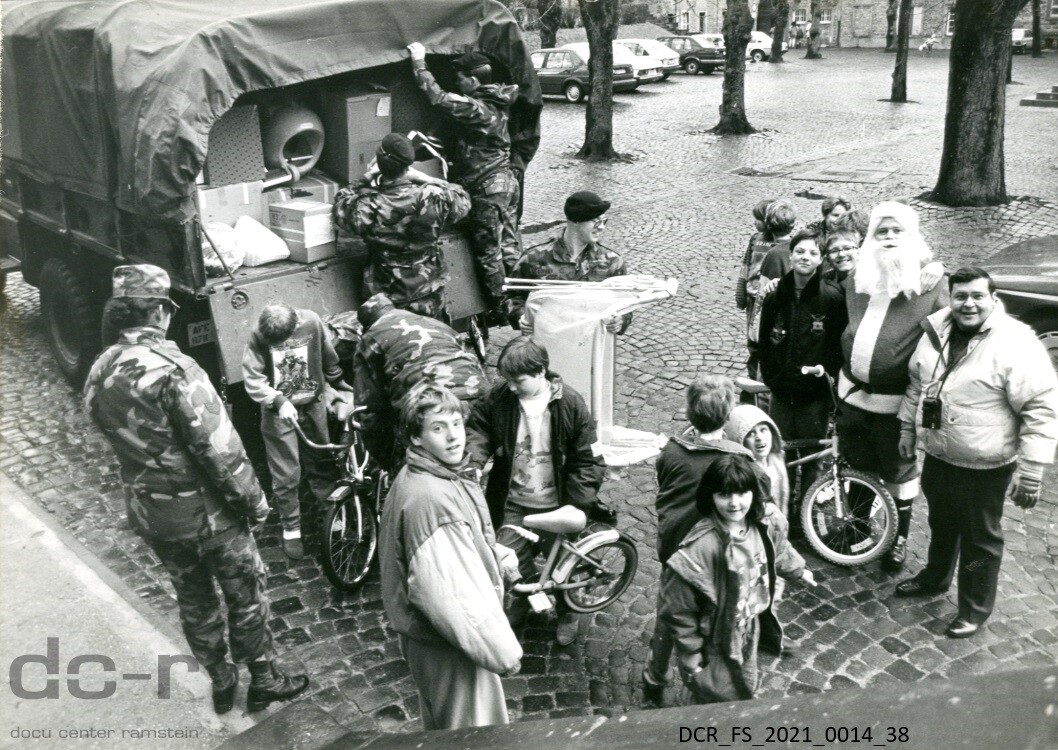 Schwarzweißfoto, US-Soldaten laden Kinderfahrräder und andere Spenden von einem Laster ("dc-r" docu center ramstein RR-F)