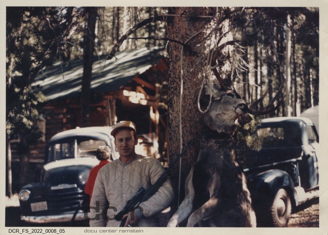 Farbfoto, Der beste Freund von Josef Fuchs in den USA vor einer Blockhütte nach der Jagd ("dc-r" docu center ramstein RR-F)